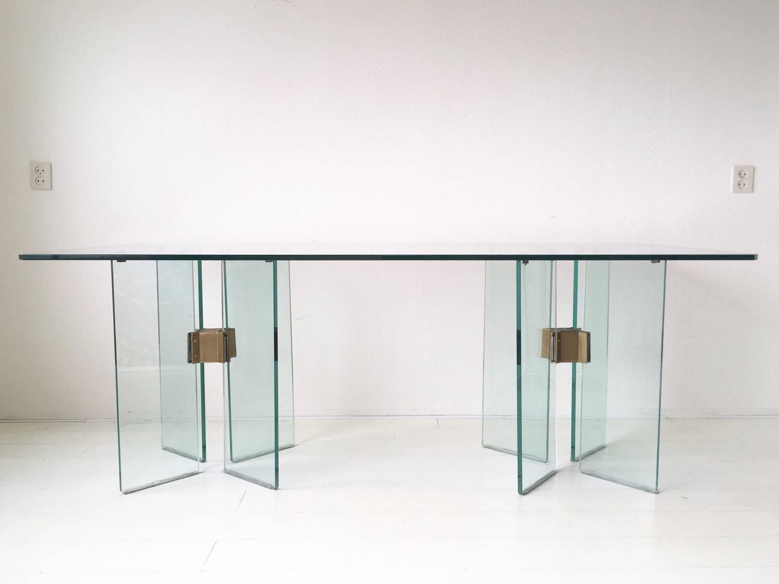 Cette table de salle à manger avec une base en verre de 1,5 cm d'épaisseur et des éléments en laiton est absolument magnifique. Ce modèle rectangulaire, T15, a été conçu et fabriqué par Peter Ghyczy vers les années 1970. Ce modèle n'est plus en