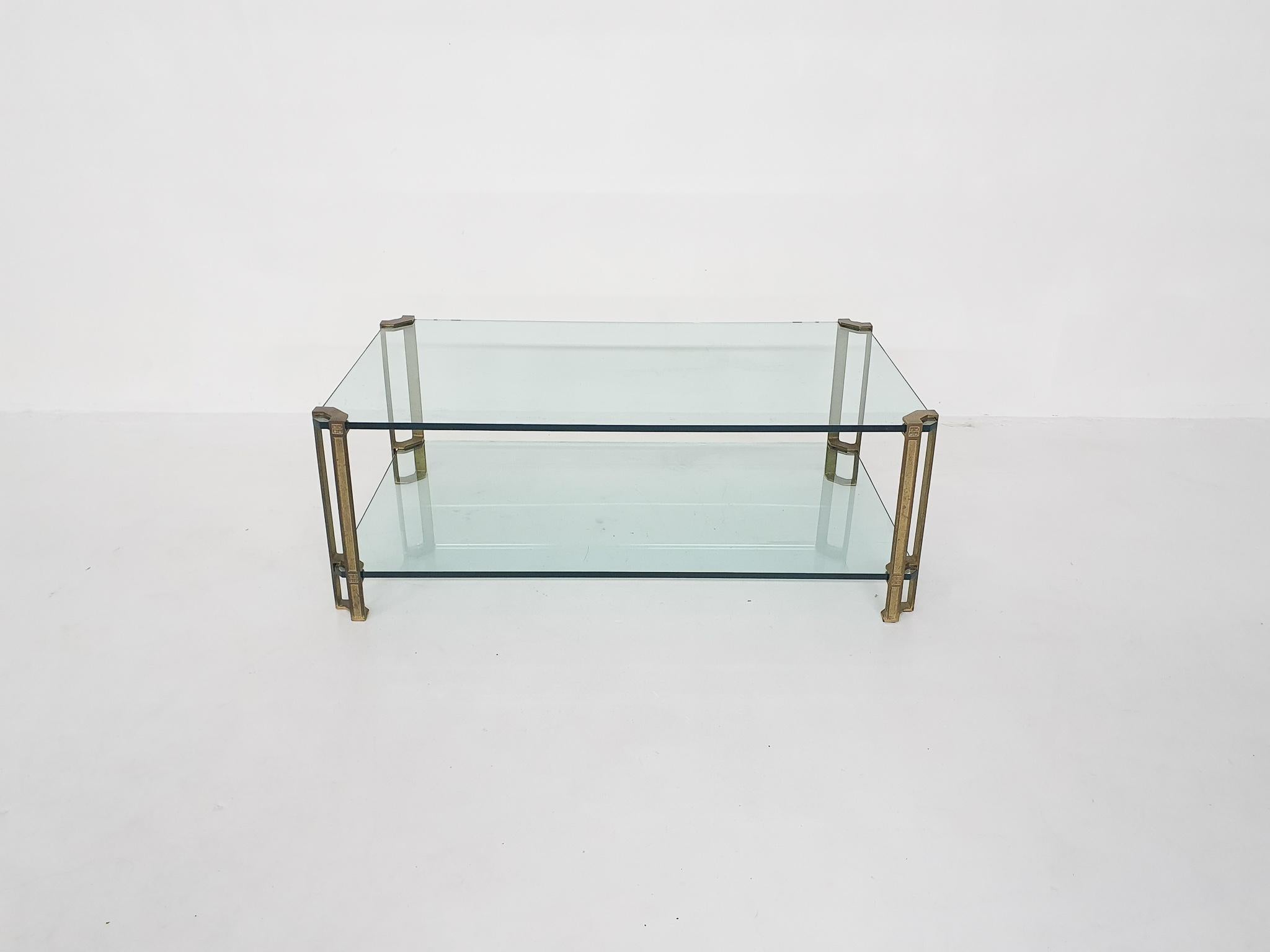 Coffee table by Peter Ghyczy. Solid brass legs and two thick glass plates.
One small chip from the corner of the glass.
