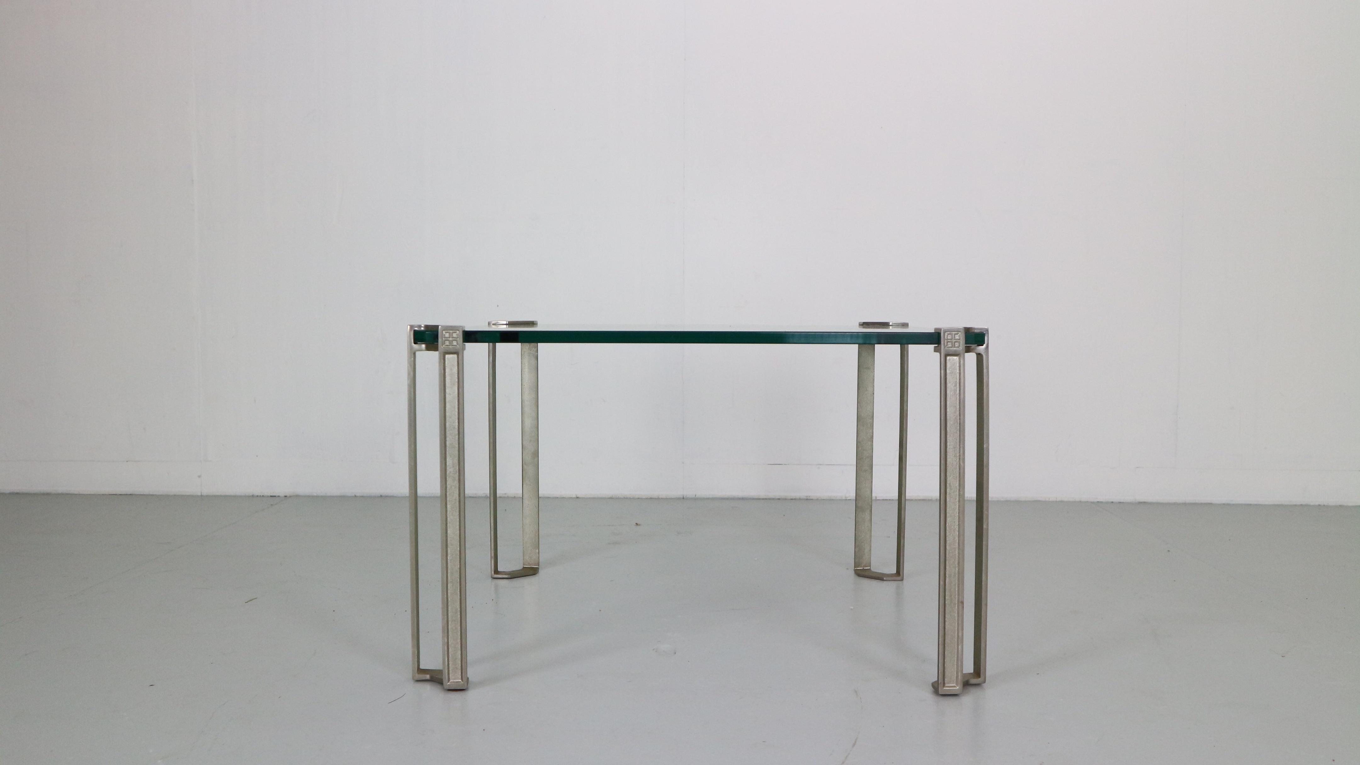 Table basse carrée en verre avec pieds en bronze moulé design by Peter Ghyczy 1970, Allemagne.

Le plateau en verre épais est soutenu dans les coins par les lourds pieds en bronze, ce qui donne l'impression qu'il flotte. 
Plateau de table en verre