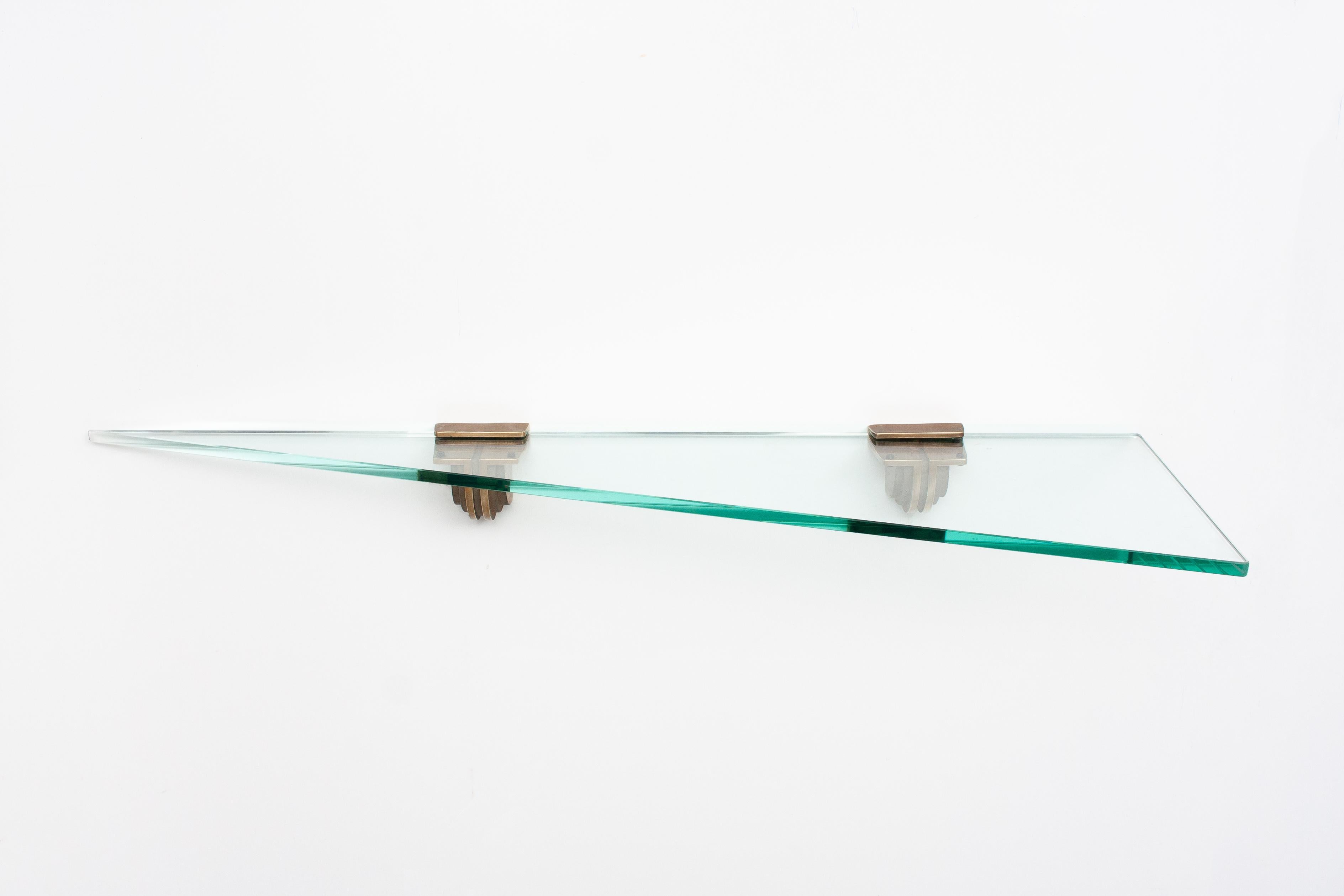 Peter Ghyczy glass wall shelve 1970. Two bronze brackets holding a thick green cut glass
shelve. In the original slice shape.