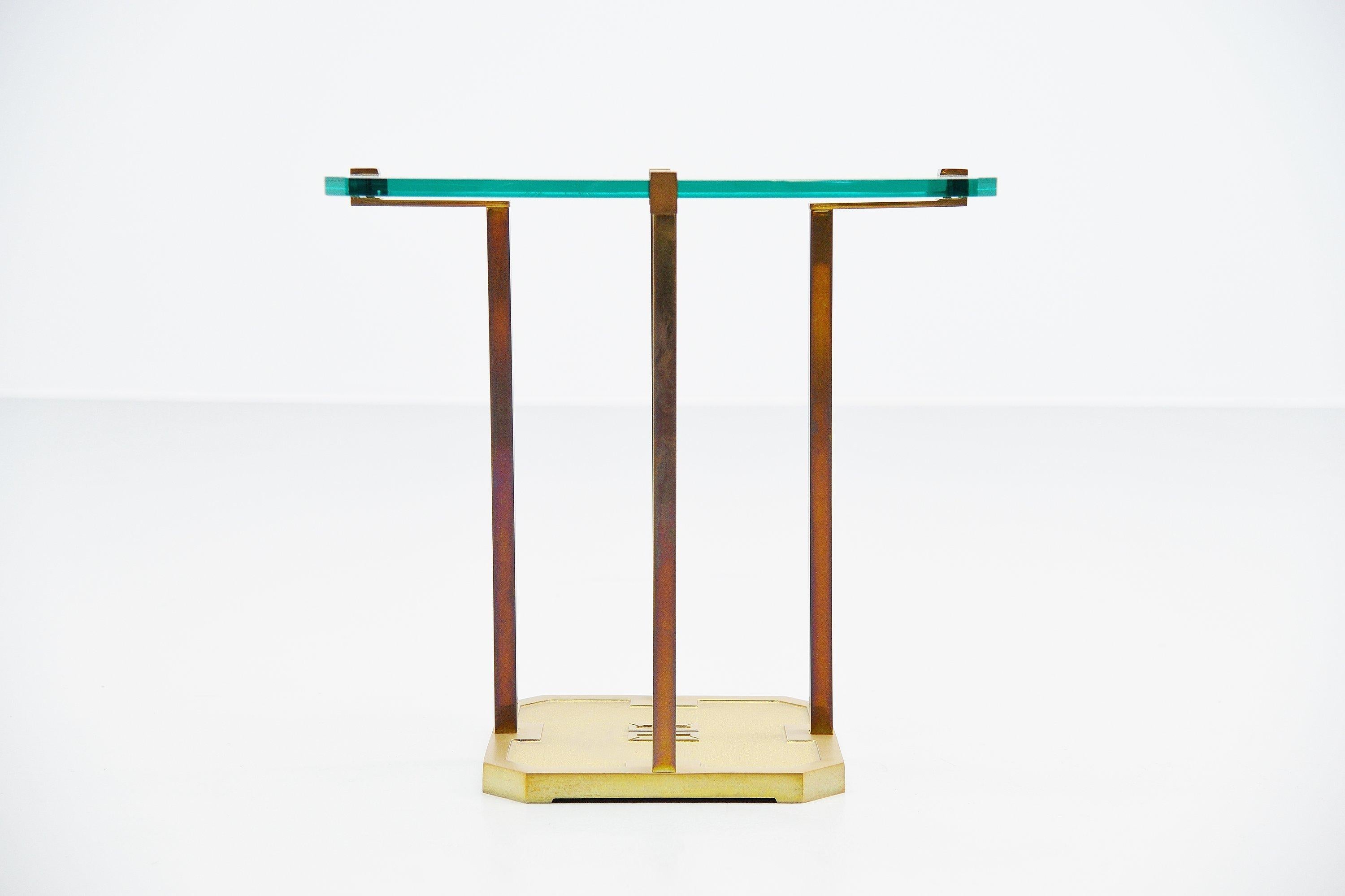 Sculptural brass side table designed and manufactured by Peter Ghyczy, Holland, 1985. This table has a solid brass sculptural frame with a square hardend glass top. Very nice shaped side table by Peter Ghyczy. In the base there is a typical monogram