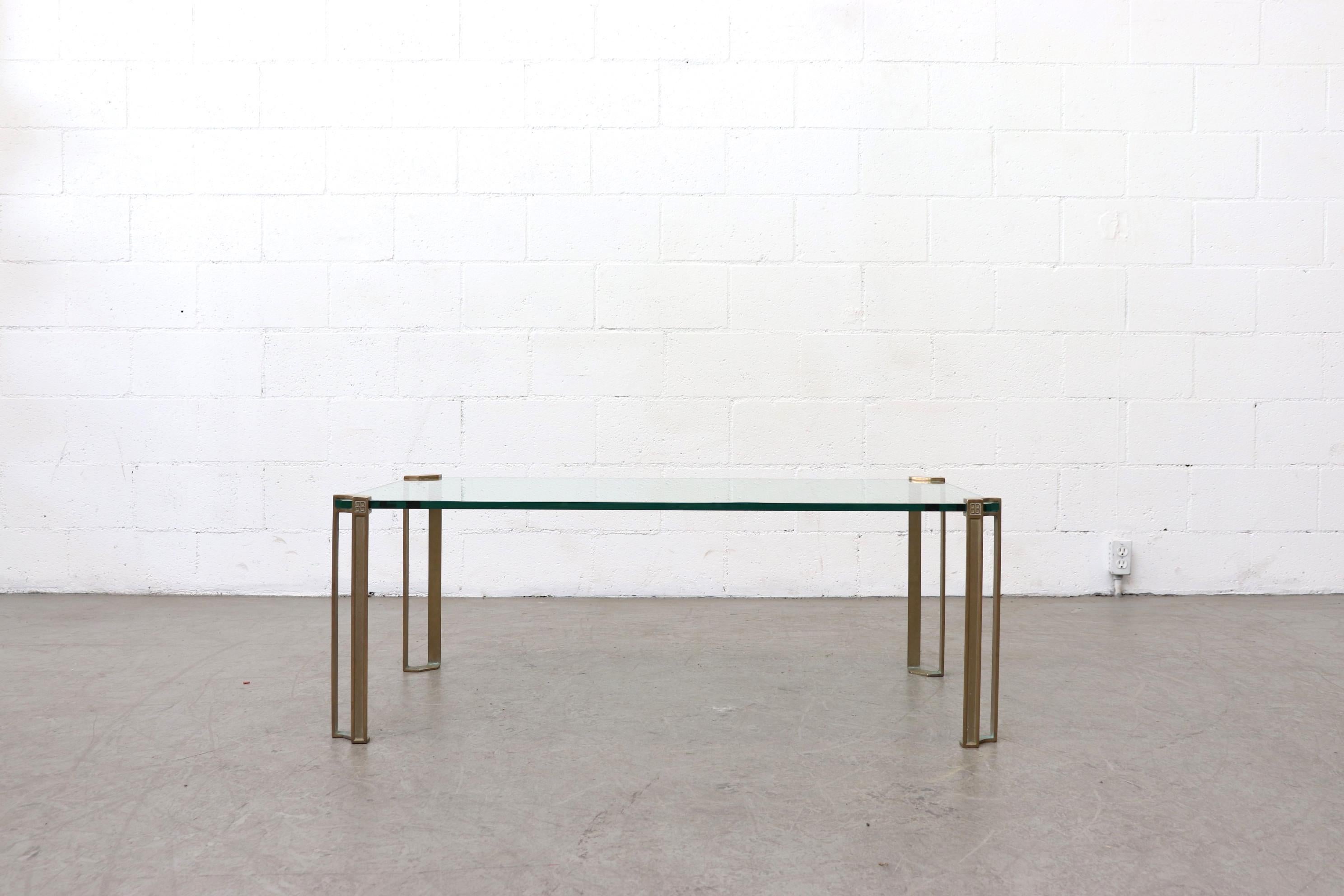 Single tiered brass and glass coffee table with oriental influence. 'Floating Glass' frame less glass coffee table. In original condition with very minimal signs of wear - I.E hardly noticeable chipping and very little scratches to glass. Nice