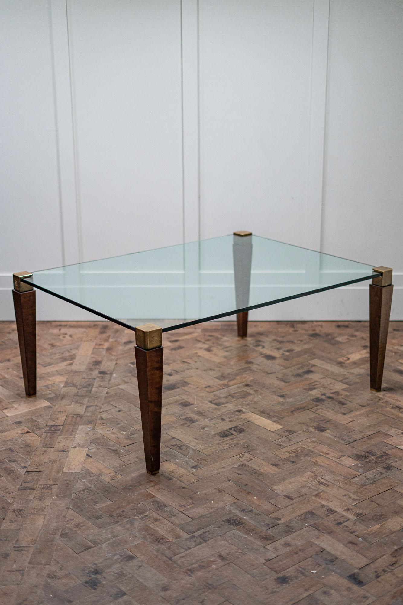 Peter Ghyczy T56 coffee table, 1990s. This table has brass and hard wood legs with 15ml toughened glass top.

The legs are cleverly designed to grab the glass and hold it in place which I believe was a design by Ghyczy.

Height - 52 cm
Length -