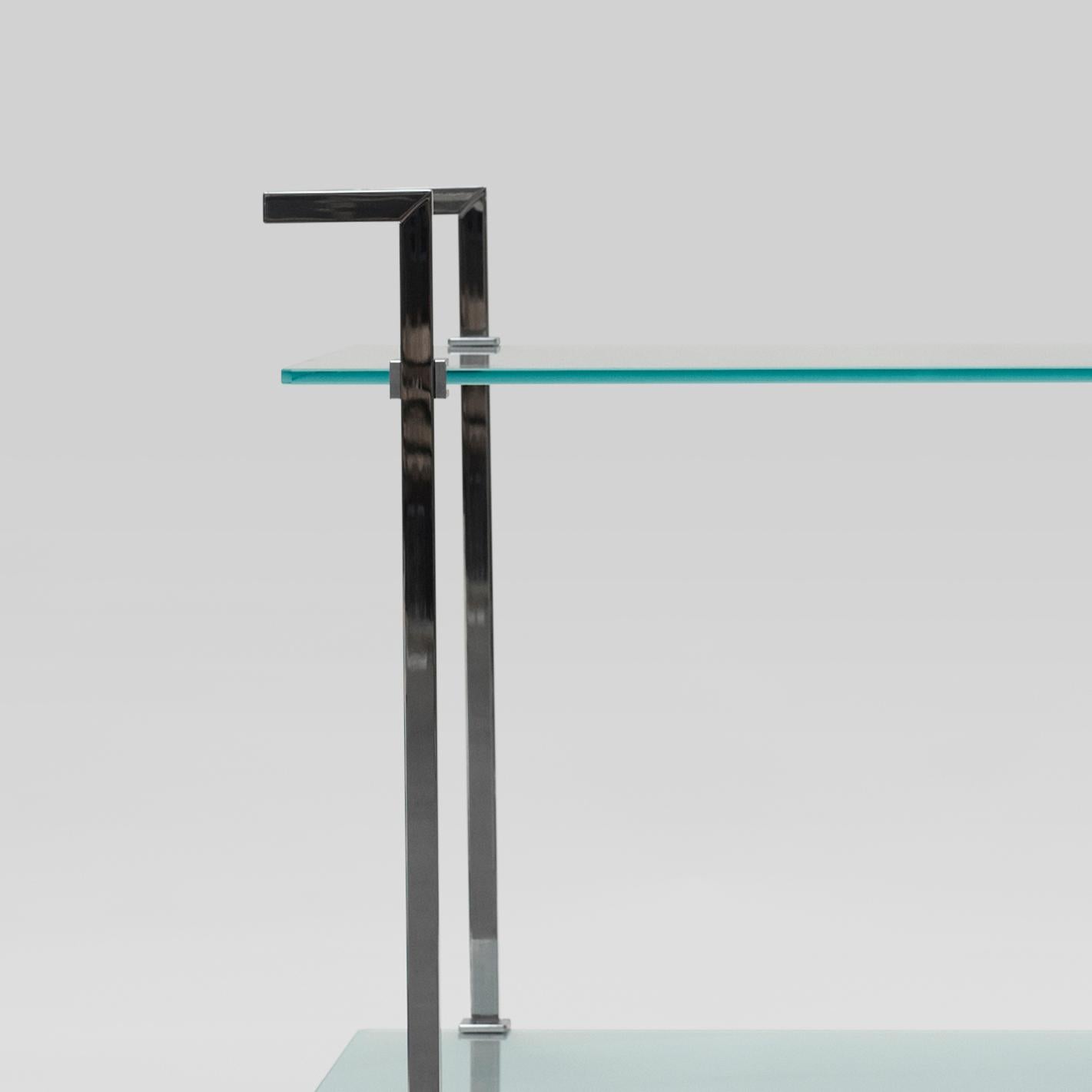 Tea trolley designed by Peter Ghyczy in 2004.
Manufactured by Ghyczy, (Netherlands)

This slender tea trolley is a piece of art on its own. Two tempered glass plates connect the metal frames. Small cast metal details secure the transparent