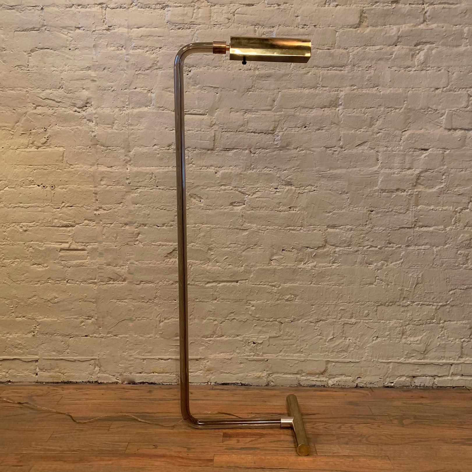 Modernist floor lamp by Peter Hamburger for George Kovacs features a curved, tubular smoked Lucite stem with brass shade and counterbalance. The shade circulates from reading position to up light.