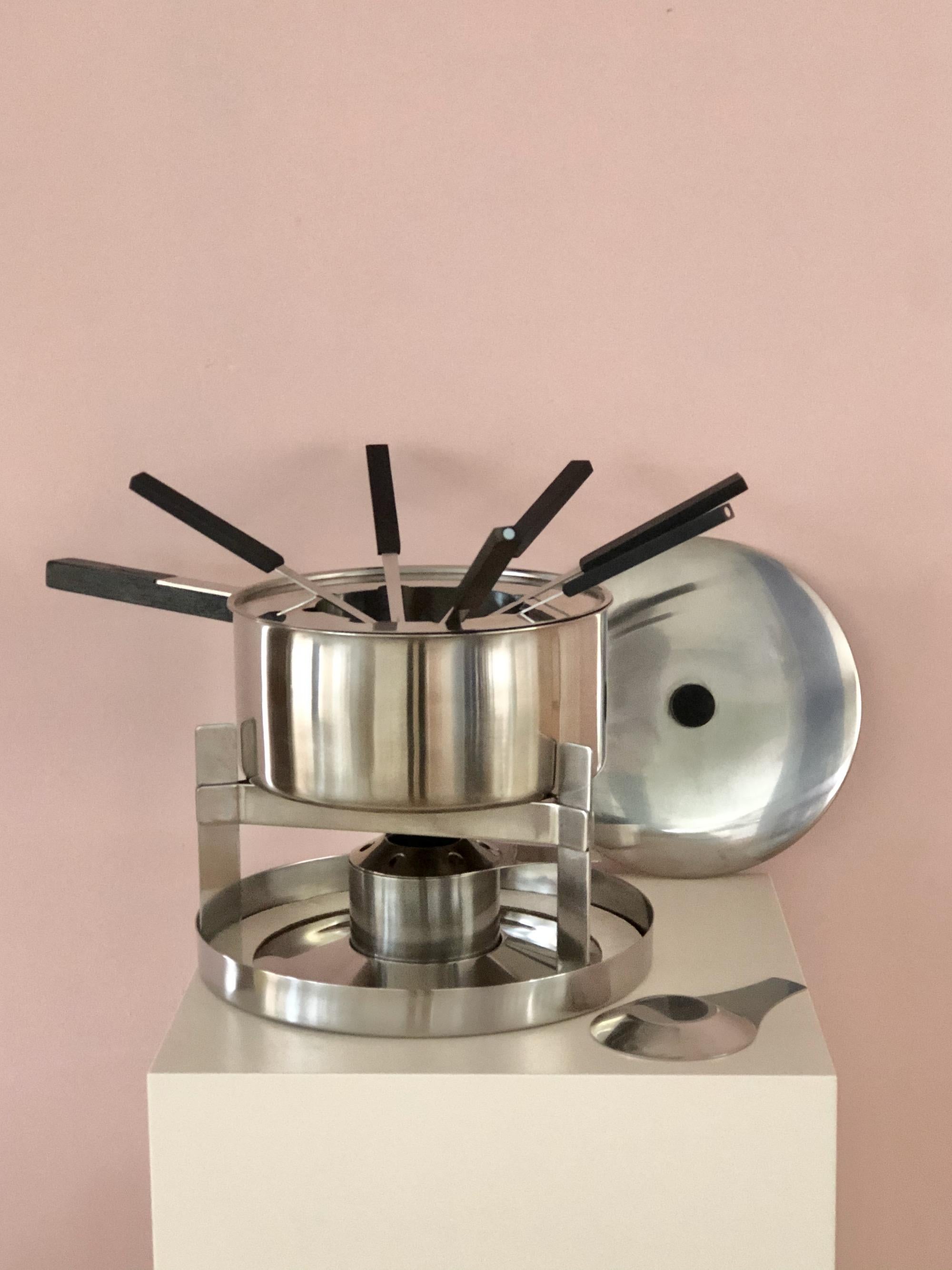 Stainless steel fondue set with wood handle, designed by Danish mid-century designer Peter Homblad (stepson from Arne Jacobsen) for Stelton, Made in Denamrk. This set comes with original Stelton Fondue Forks and is ready to use.