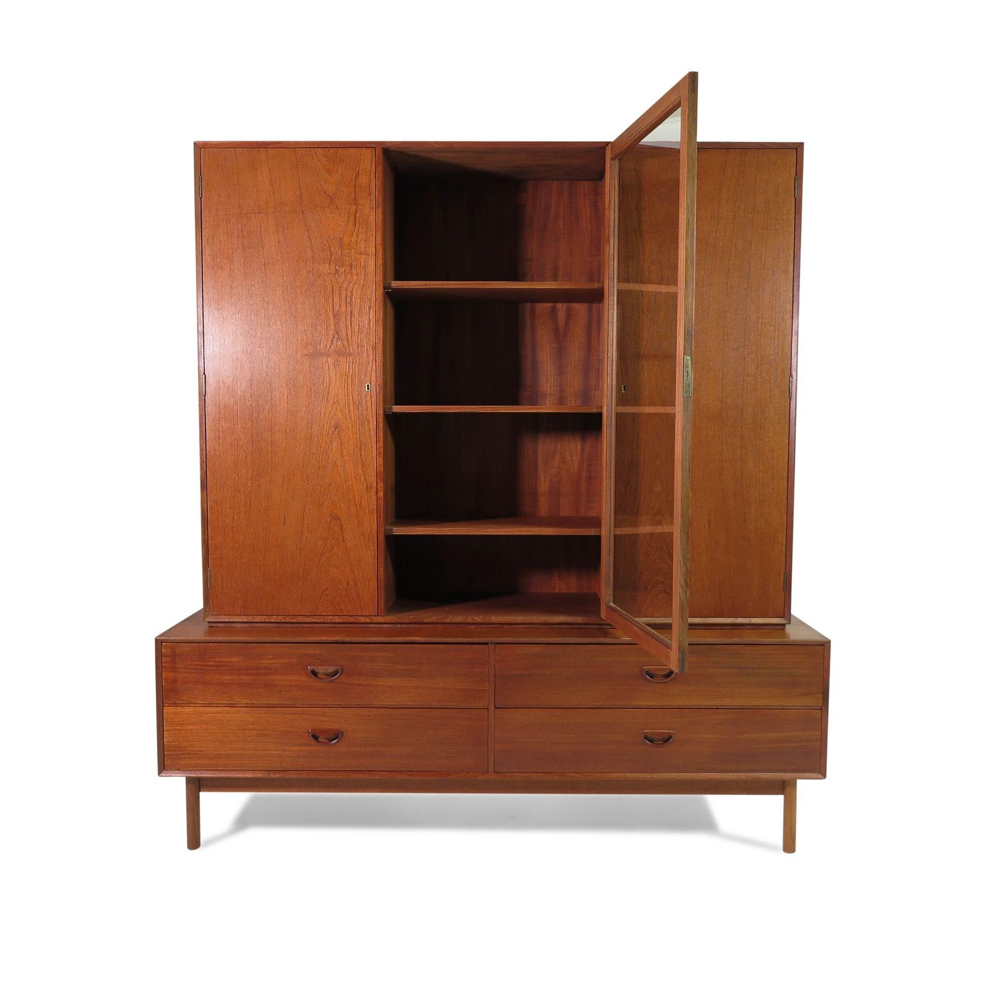 Danish solid teak cabinet designed by Peter Hvidt, 1955, Denmark. This rare design by Peter Hvidt is crafted of solid teak with carved pulls and exposed joinery on edges. Features locking cabinet with doors, over cabinet with four drawers.