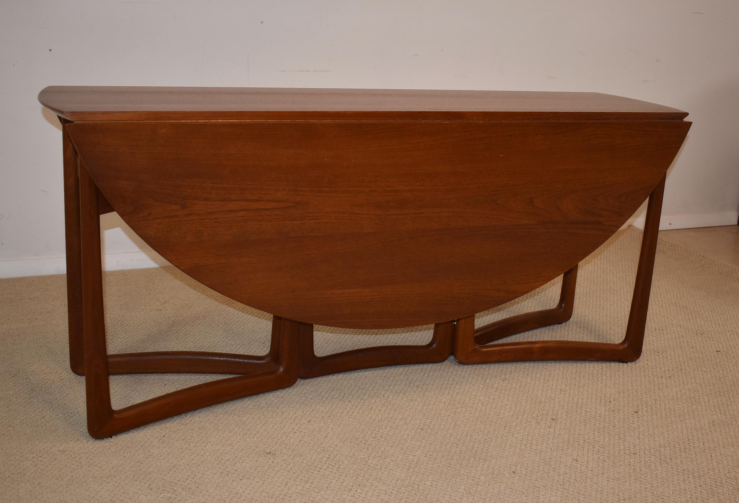 Danish drop-leaf dining table designed by Peter Hvidt and Orla Mølgaard-Nielsen. Table is solid teak wood with brass details, and is in excellent vintage condition. Manufacturer John Stuart, New York label on the bottom, 1950s. Measures: Closed 64