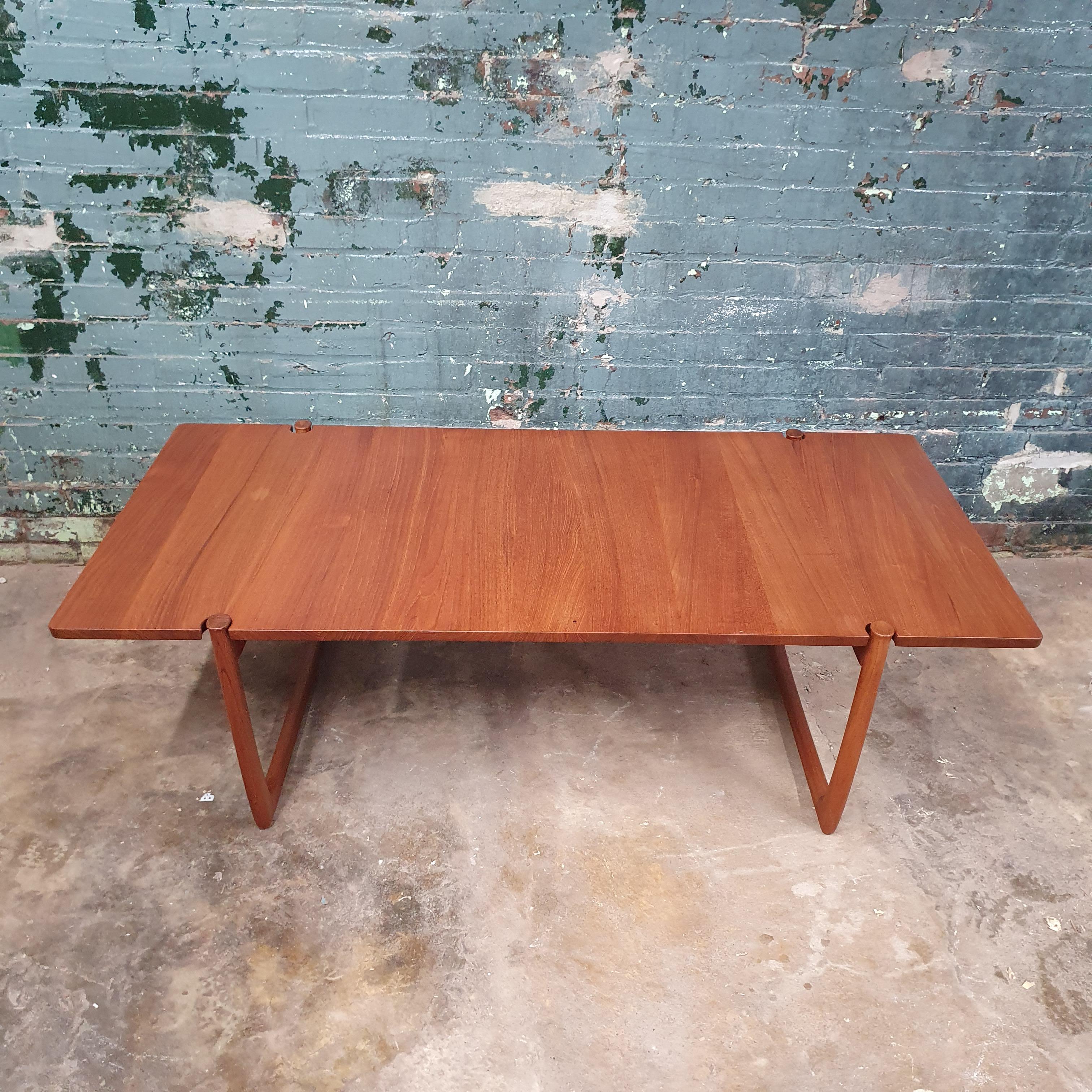 beautiful solid teak coffee table by peter hvidt and orla mølgaard-nielsen for France and sons. this table has beautiful details including the joinery joining the solid teak top visible in the end grain. sculpted legs with a great