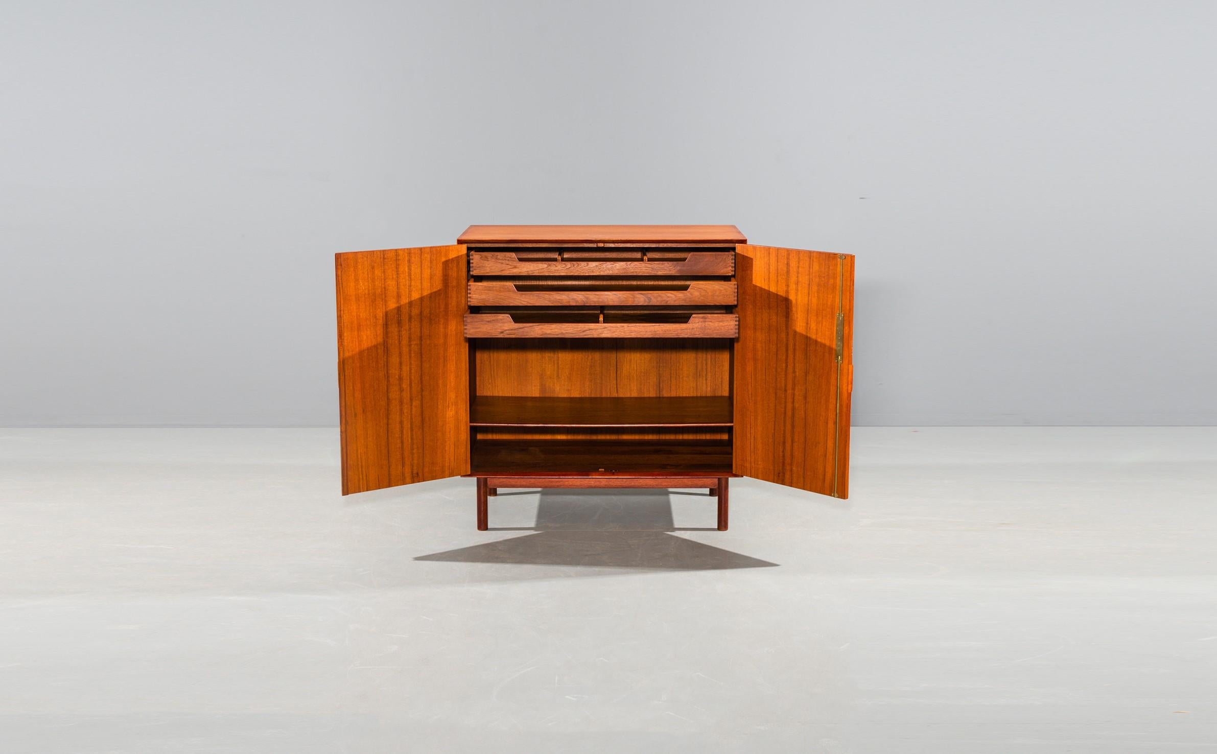 Wonderful teak cabinet with two doors, brass hinges and inside drawers. Designed by Peter Hvidt and Orla Mølgaard-Nielsen in the 1960s. Produced by Søborg Møbler. Beautiful details. Visible dovetail connections. Solid teak frame, wood with wonderful