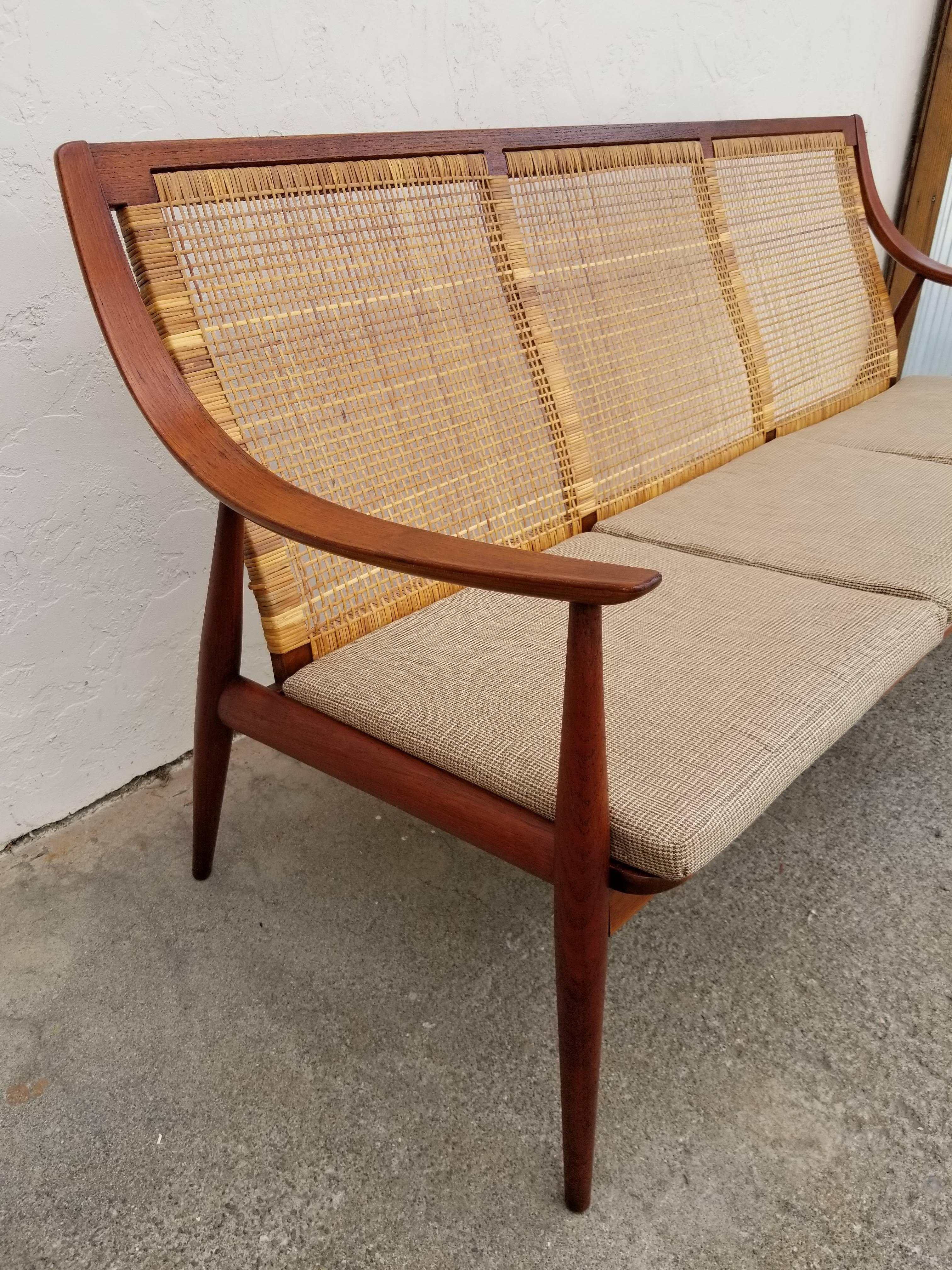 A nice example of this architectural and sculptural design by Peter Hvidt and Orla Mølgaard-Nielsen, circa 1960. Crafted in solid teak, original wicker back in excellent condition. Rich, deep color to teak frame, new upholstery recommended.