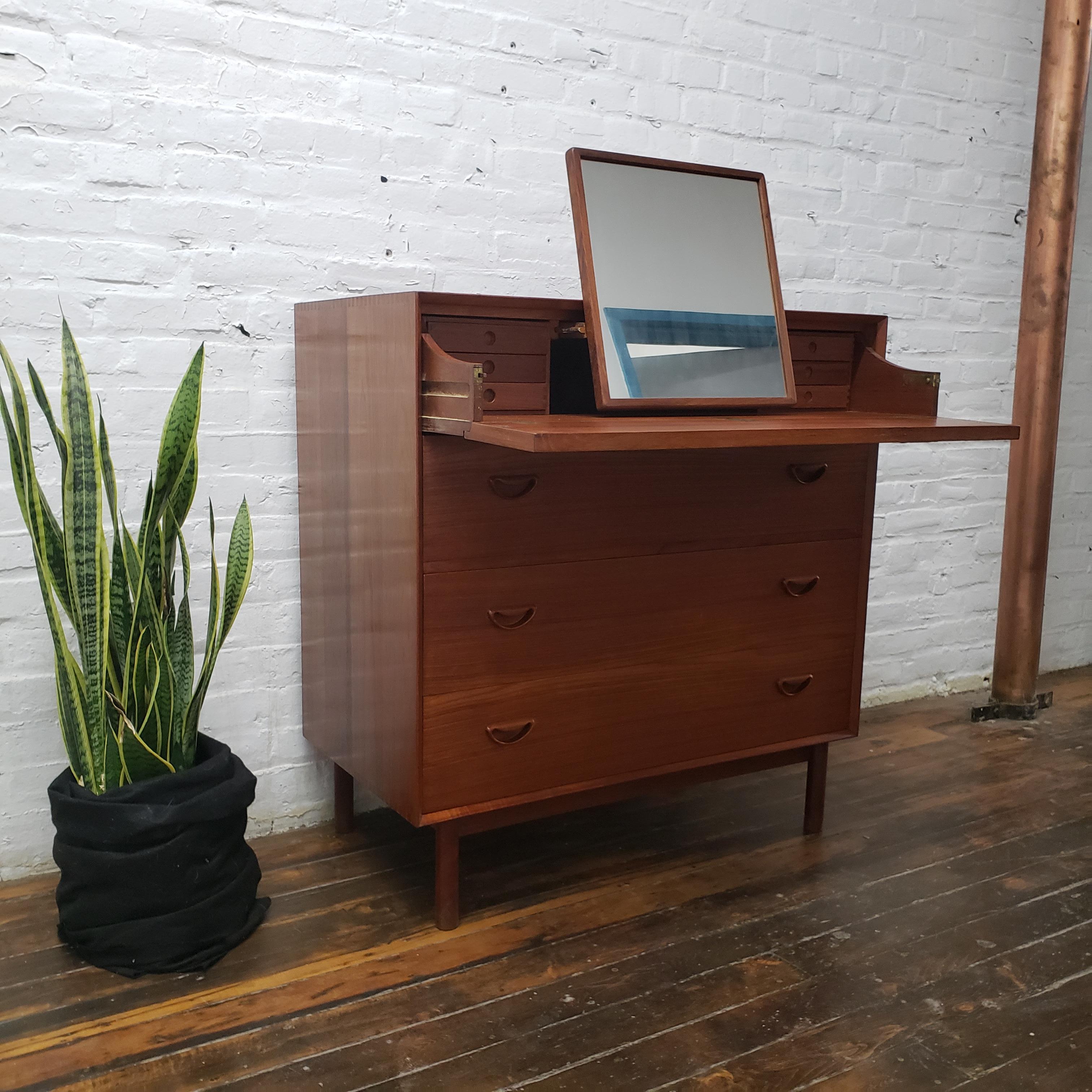 Beautiful solid oiled teak dresser by Peter Hvidt and Orla Molgaard-Nielson made in Denmark for Soborg Mobler. The dresser features 3 working drawers and has a pullout / pull-out vanity in the top fall front drawer with mirror and 6 small drawers
