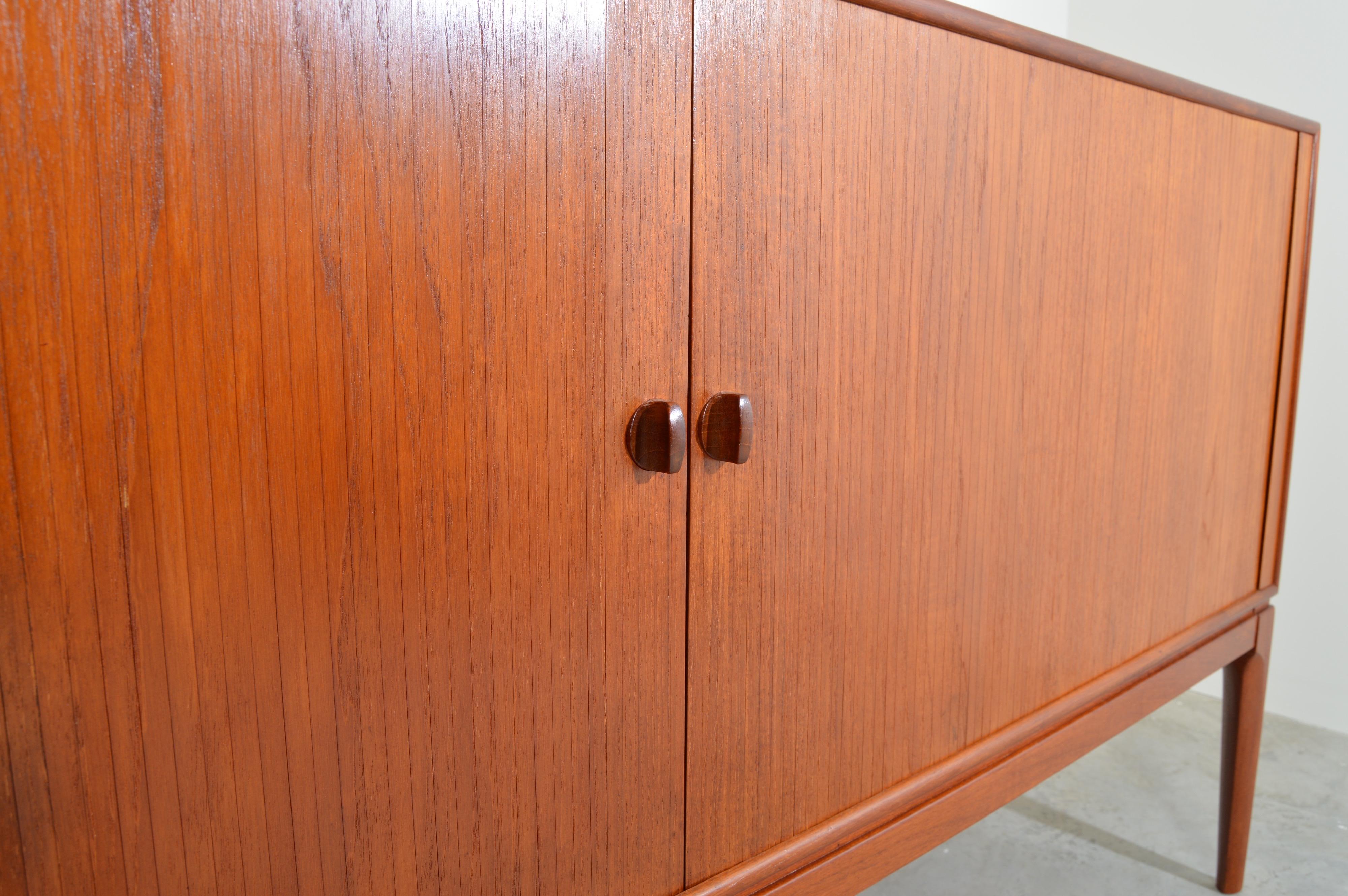 Rare and beautiful Tambour credenza having high legs designed by Peter Hvidt & Orla Molgaard-Nielsen. 
Ample center drawer and case storage.
Beautiful, well maintained condition. Clean and ready for use!