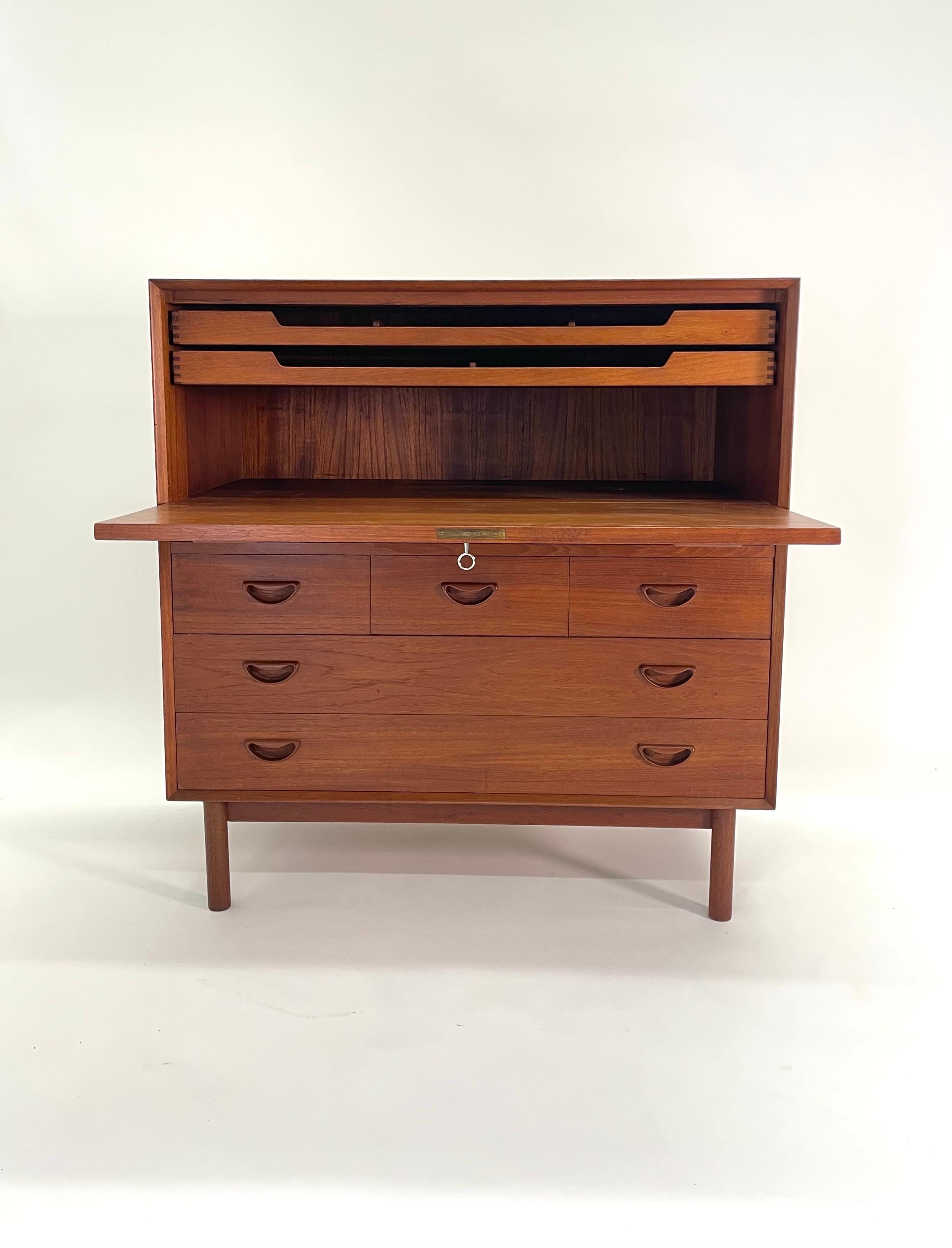 Peter Hvidt and Orla Molgaard-Nielsen drop front solid teak desk opens to drawers with beautiful dovetail joinery. The piece has three small drawers below and two larger drawers. Perfect desk for small space like a New York apartment. It can serve