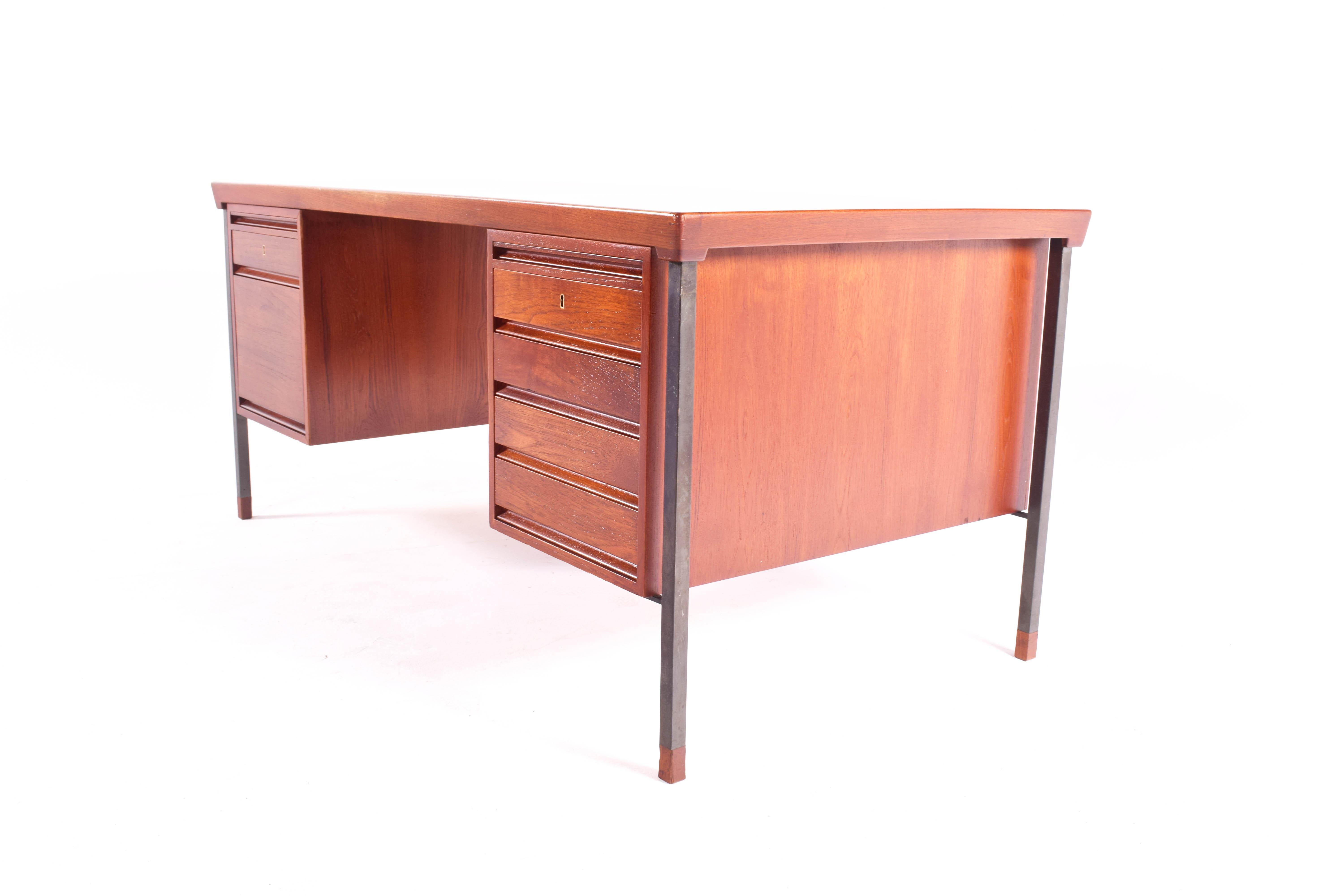 This Danish teak desk was designed by Peter Hvidt and Orla Molgaard-Nielsen for Soborg Mobelfabrik in the 1960s, Denmark. It features six drawers with small removable trays, and two trays that slide out. This desk is finished on both sides, and