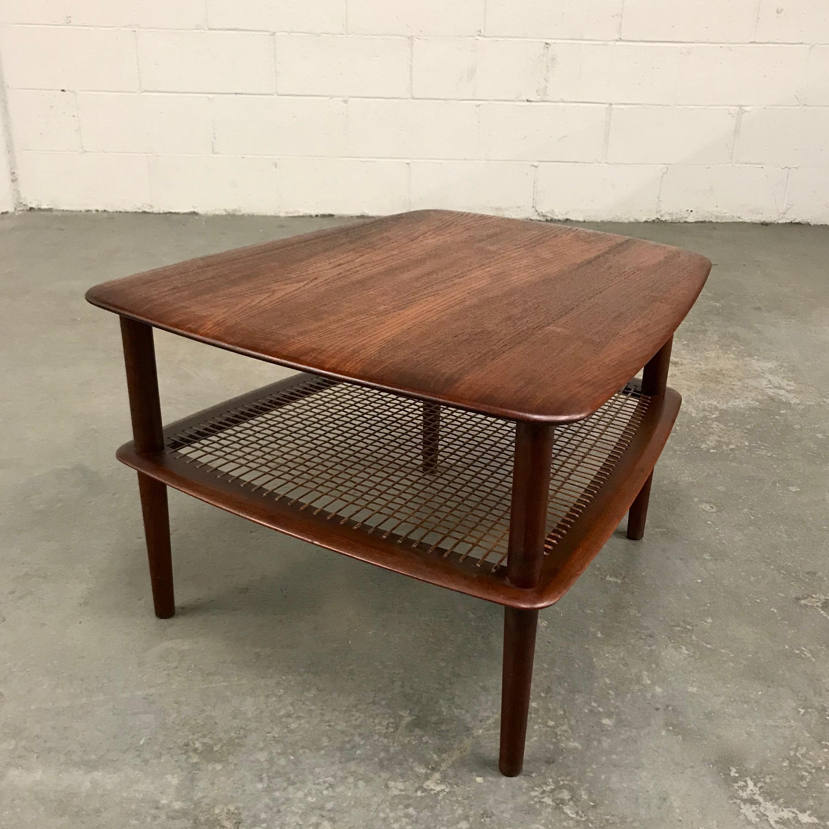 Danish modern, teak side table by Peter Hvidt and Orla Molgaard Nielsen for France & Daverkosen features 2 tiers with caned lower shelf. Measures: The table tapers from 19.5 to 25.5 inches with the lower shelf height at 10 inches.