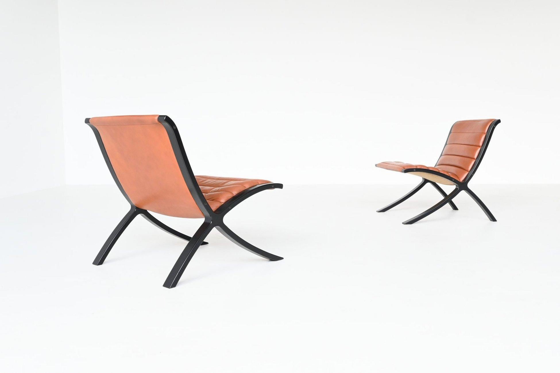 Fantastically shaped pair of lounge chairs model X-Chair designed by Peter Hvidt & Orla Molgaard-Nielsen for Fritz Hansen, Denmark 1979. These sculptural chairs feature a black lacquered beech plywood frame with padded brown leather upholstery. The