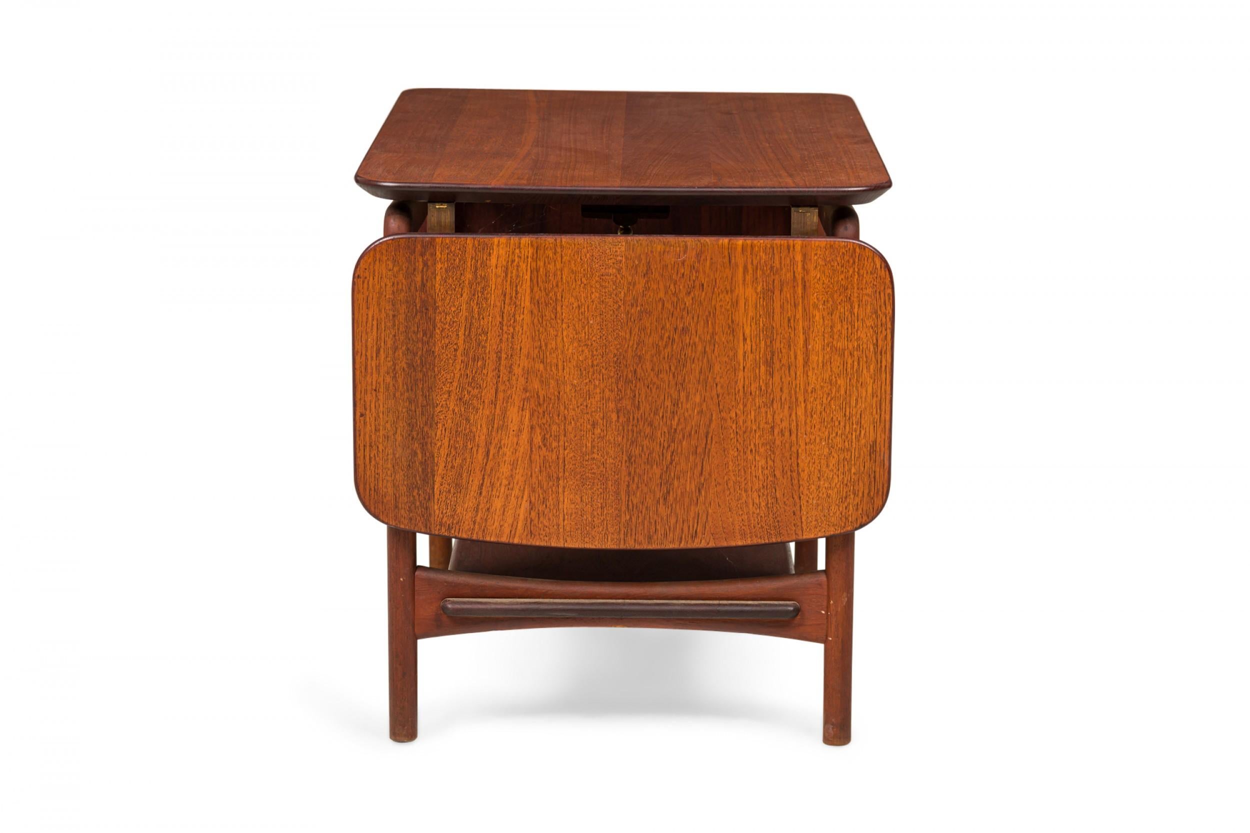 Danish Mid-Century rectangular teak end/side table with two drop leaves, supported by a four legged frame with a bottom stretcher shelf. (PETER HVIDT).
 