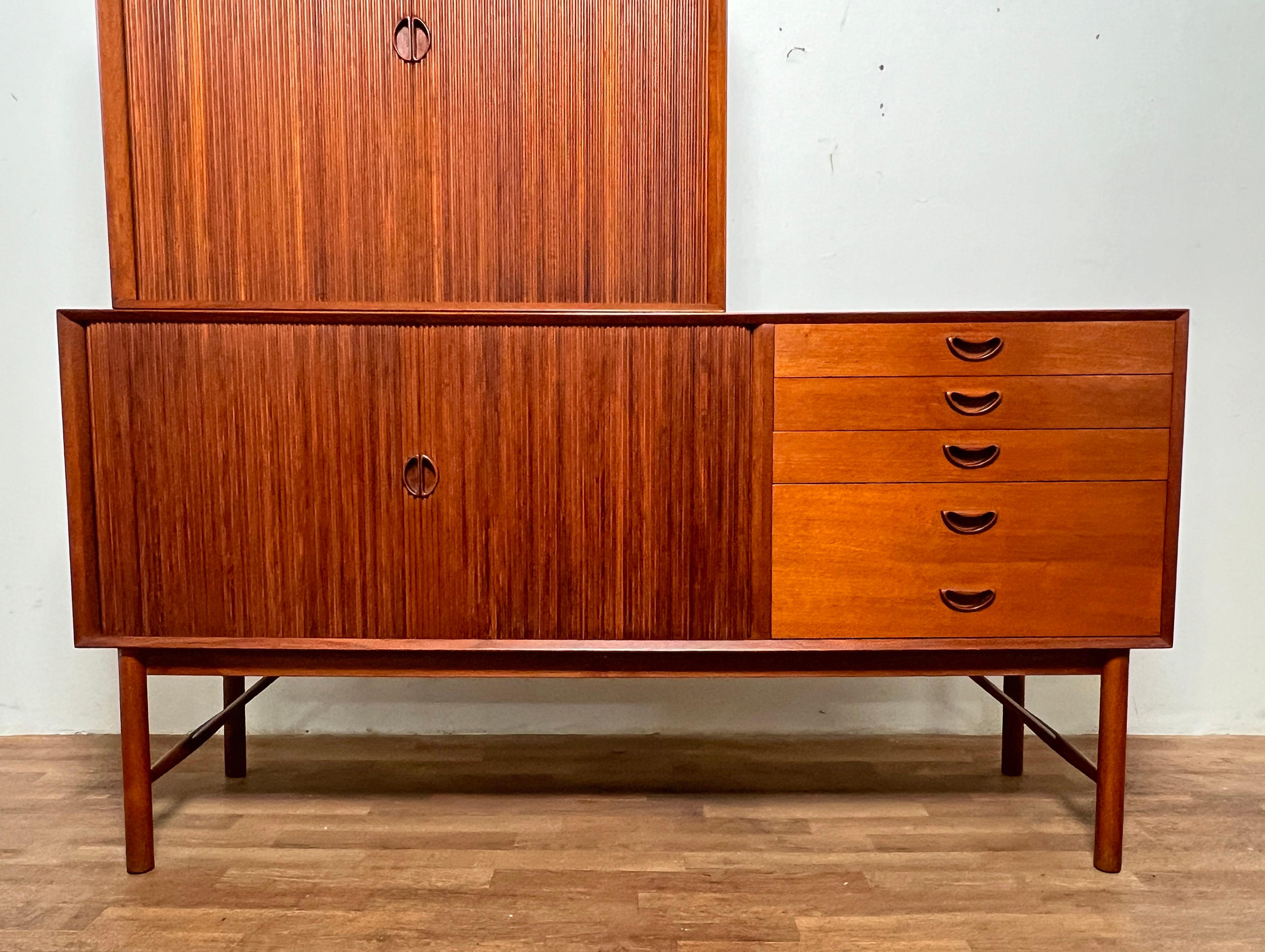 Danish solid teak tambour door credenza by Peter Hvidt for Soborg Mobler. This example features a matching tamboured top cabinet, with both pieces displaying the designer’s signature finger joinery.  Circa 1960s.

The credenza measures approx: 65