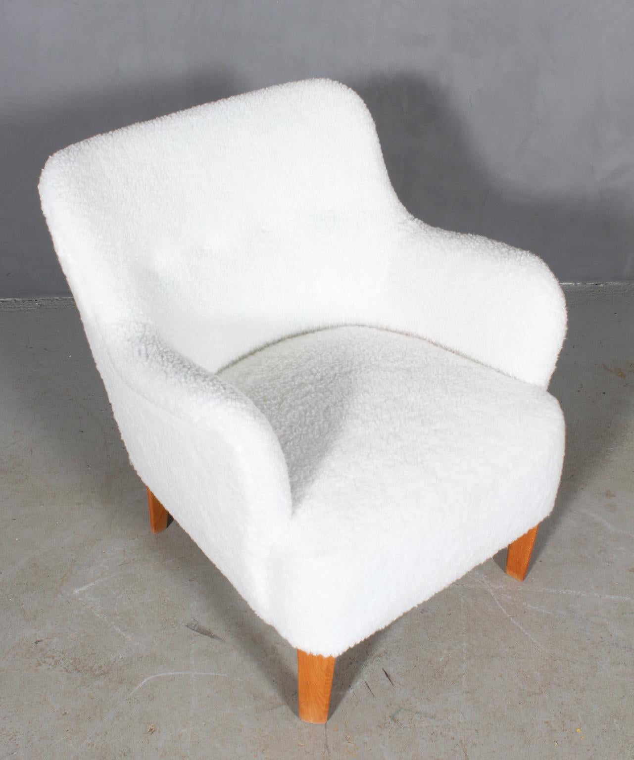 Peter Hvidt early lounge chair new upholstered with artificial sheepskin with buttons.

Legs of stained beech.

Model 1748, made by Fritz Hansen.