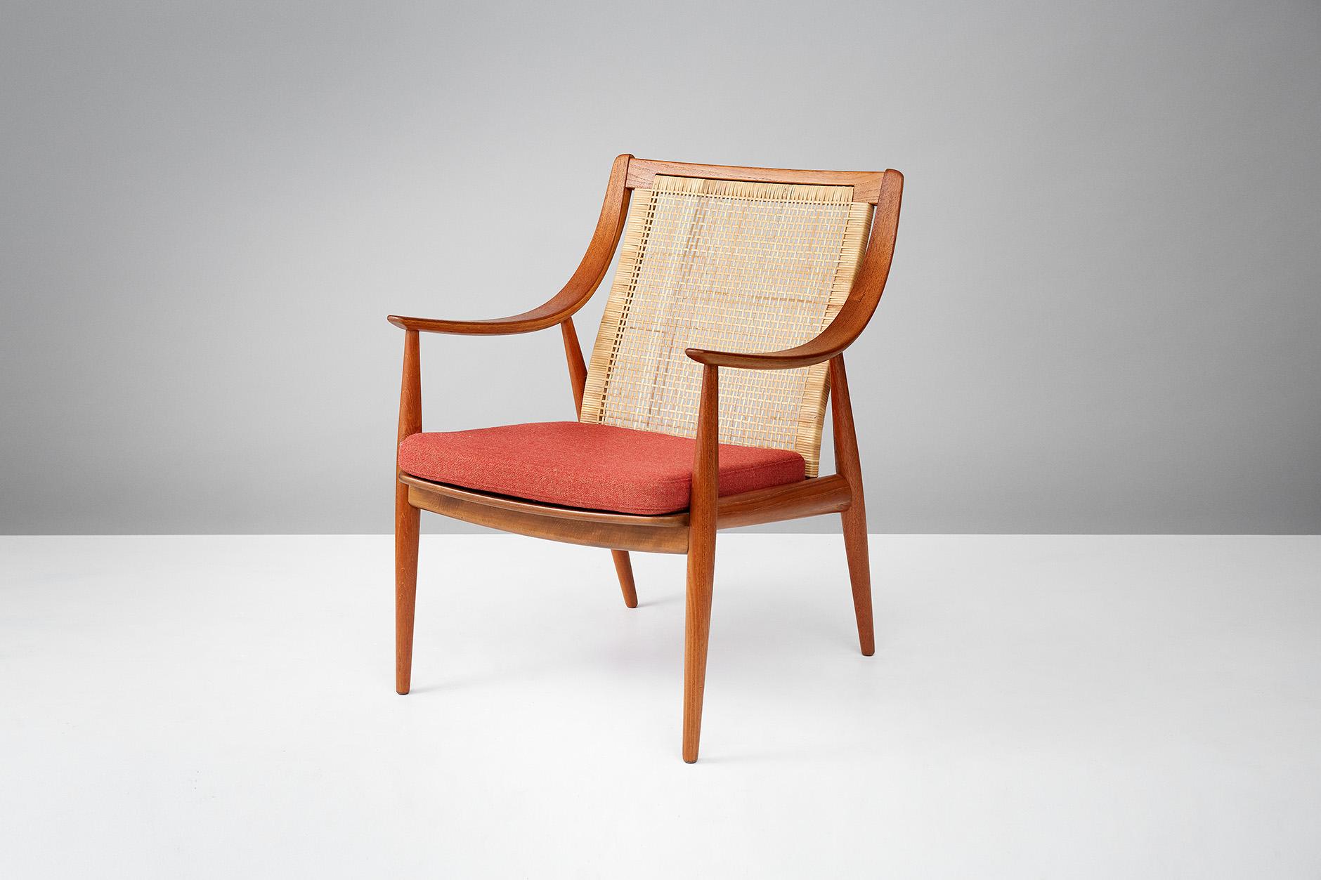 Teak armchair produced by France & Daverkosen, Denmark. Woven rattan back with new seat cushion reupholstered in burnt orange wool fabric.