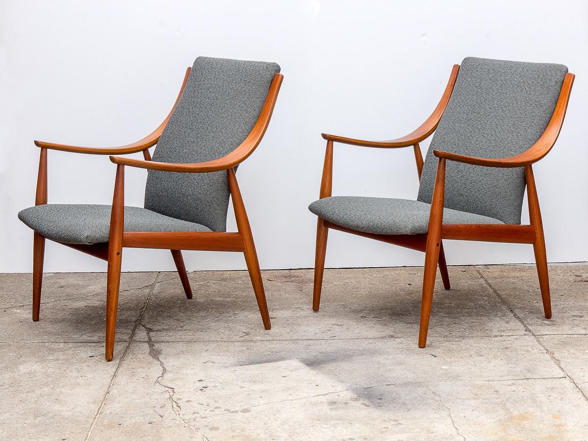 Peter Hvidt FD148 Easy chairs and ottoman set for John Stuart Inc. A brilliant pair of lounge chairs with curvilinear arms accompanied by an ottoman footrest. The chairs and fixed cushion are faithfully upholstered with a special Alexander Girard