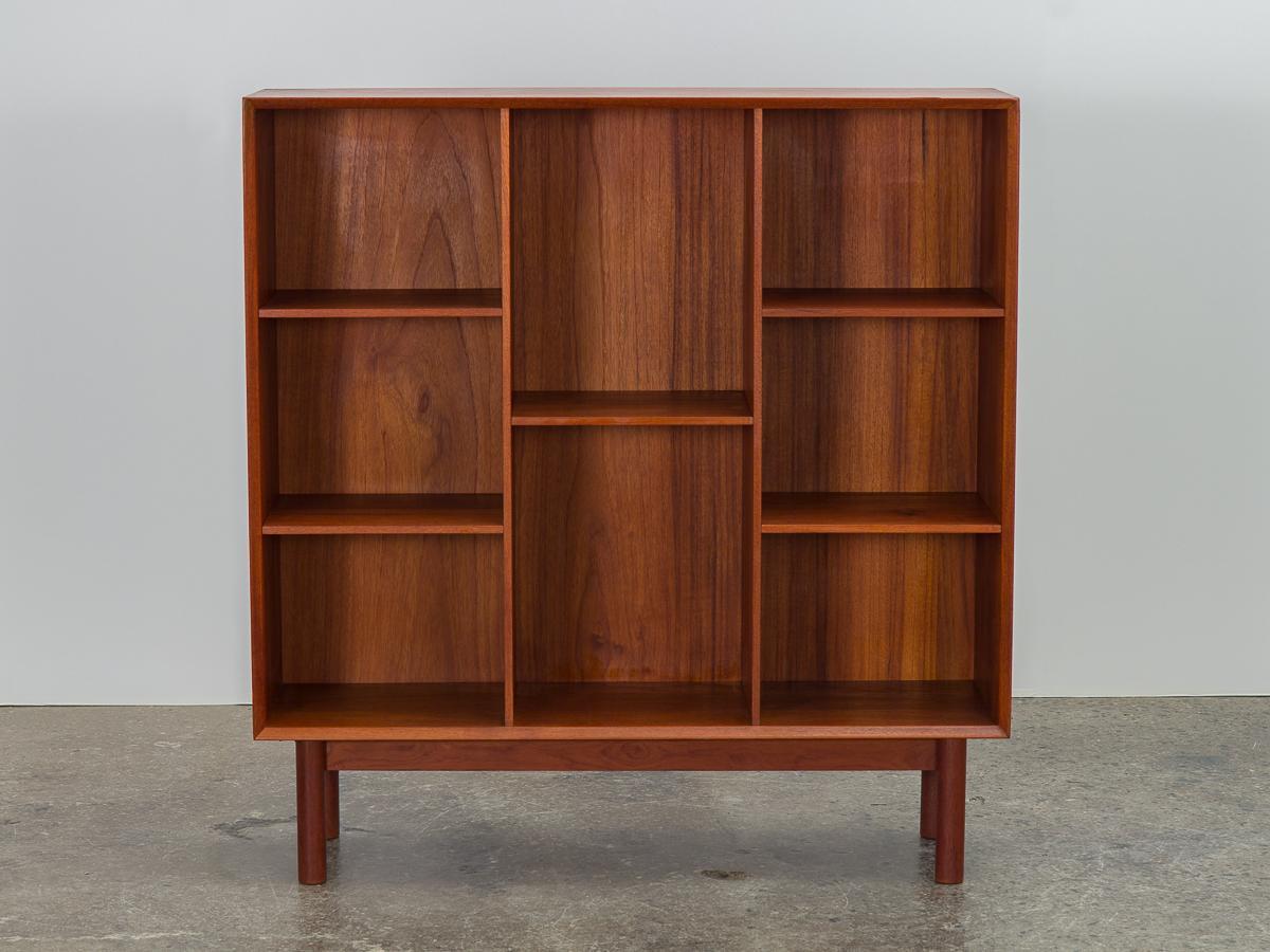 Danish modern teak modular bookcase on legs, designed by Peter Hvidt and Orla Mølgaard-Nielsen for Soborg. Minimal profile featuring nice construction details, like beveled edge and signature box joinery. This modular storage system was designed to