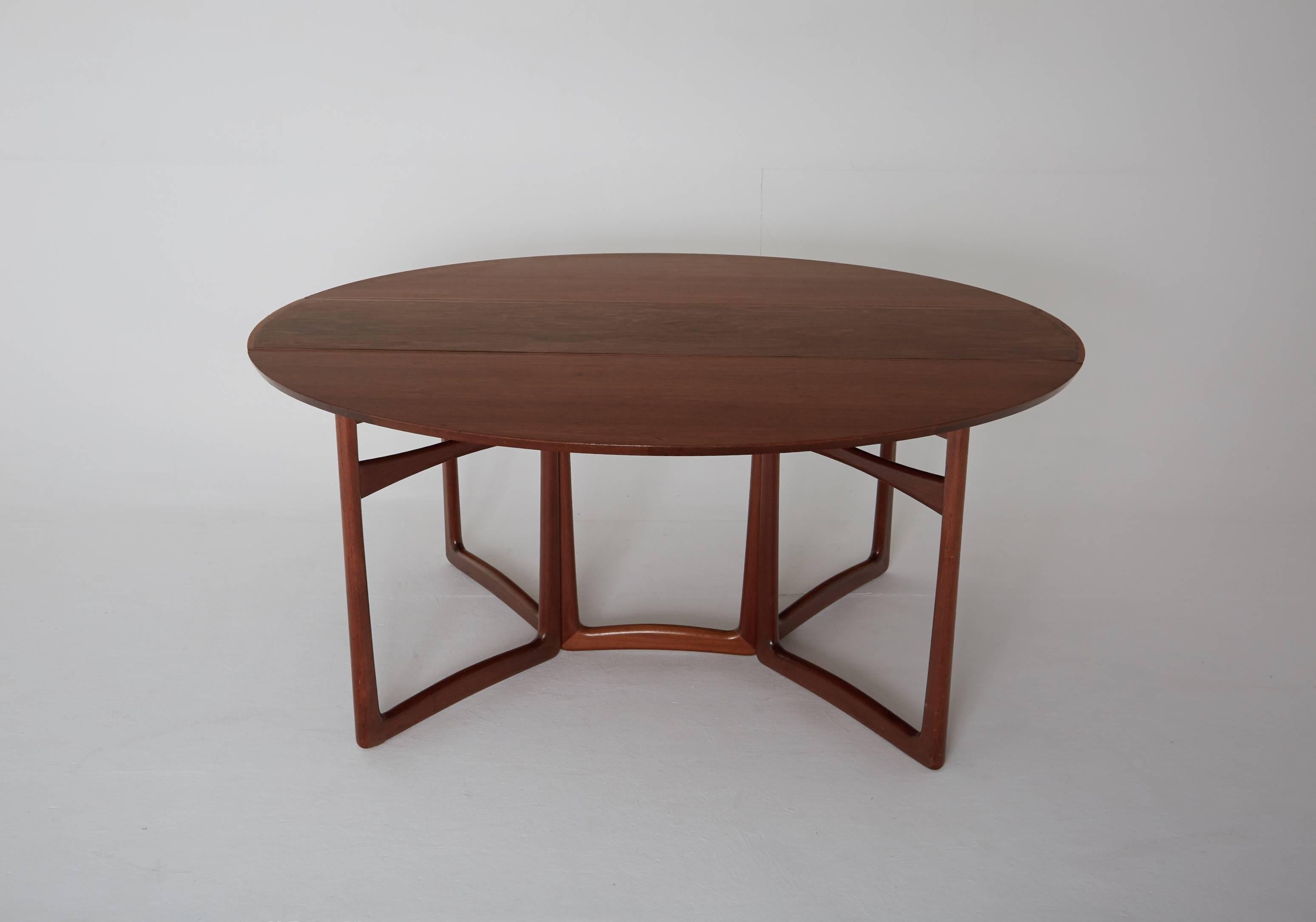 Model 20/59 folding / drop-leaf dining table was designed in circa 1955 by Peter Hvidt & Orla Mølgaard for France & Søn. Made from solid teak with two fold-down leaves, brass details and a gate leg frame. When fully extended the table is 143 cm