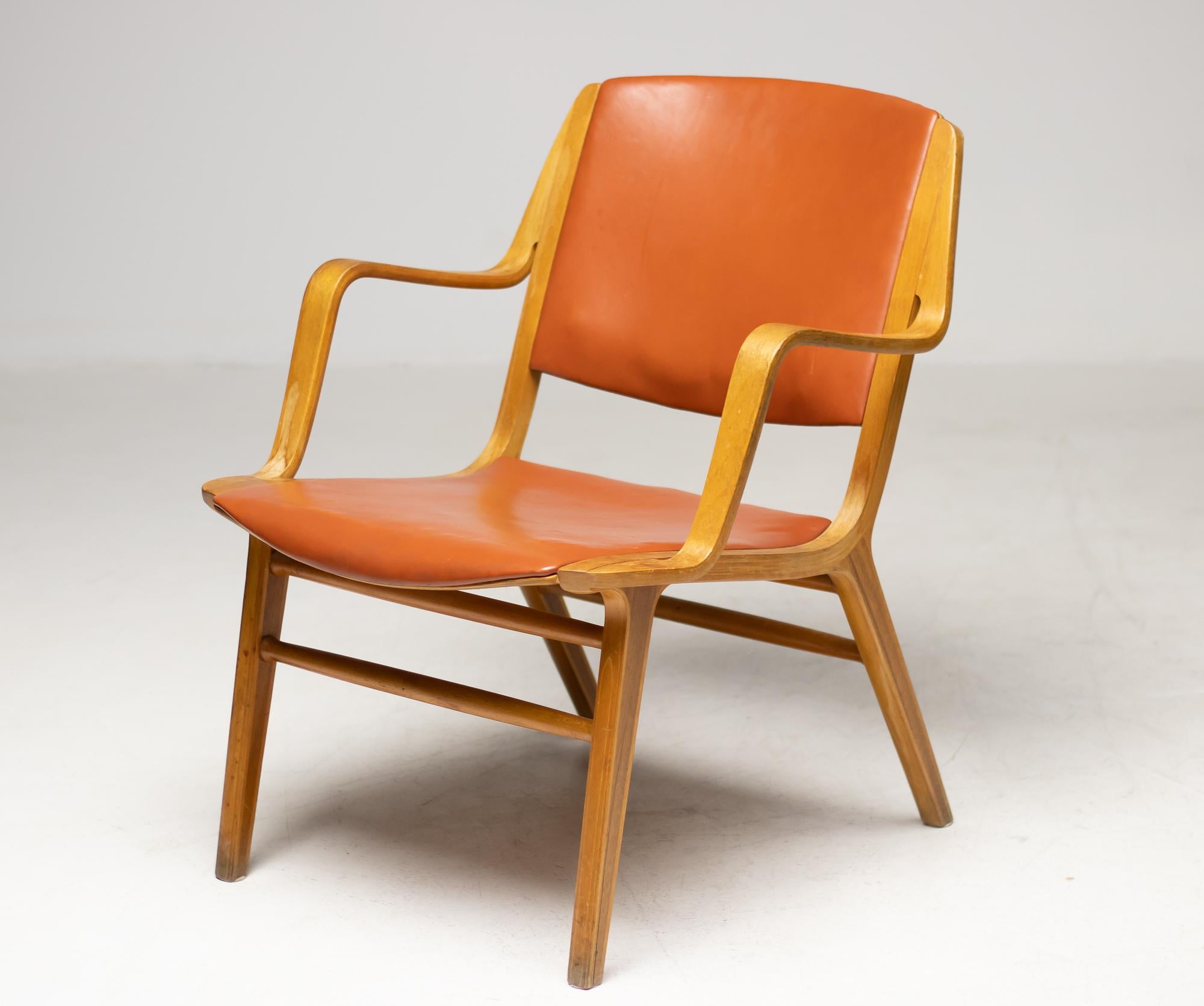 Armchair designed by Peter Hvidt and Orla Mølgaard–Nielsen and produced by Fritz Hansen, Denmark. The chair is press shaped in laminated beechwood, the seat is upholstered with all original orange leather. The legs feature a teak core.
An example