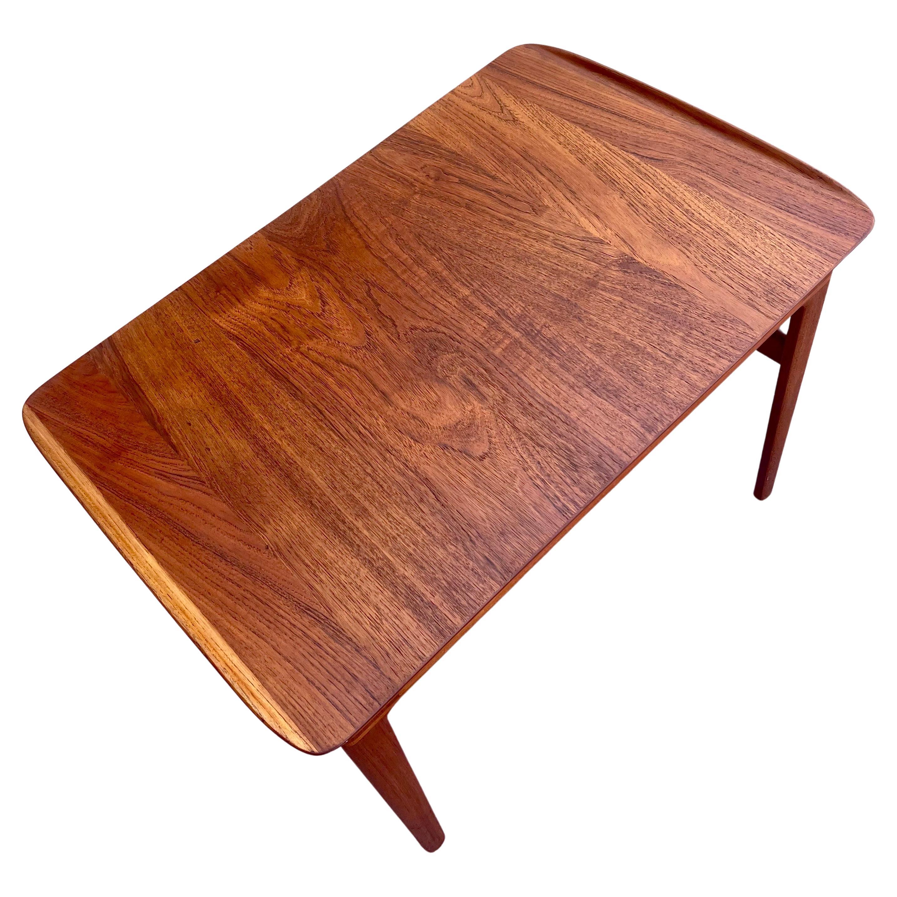 Beautiful rare solid teak end cocktail table designed by Peter Hvidt, imported by Jhon Stuart, and manufactured by France and Sons, circa 1950s, solid teak with drawer and raised ends edge. incredible craftsmanship, we have it refinished and oiled.