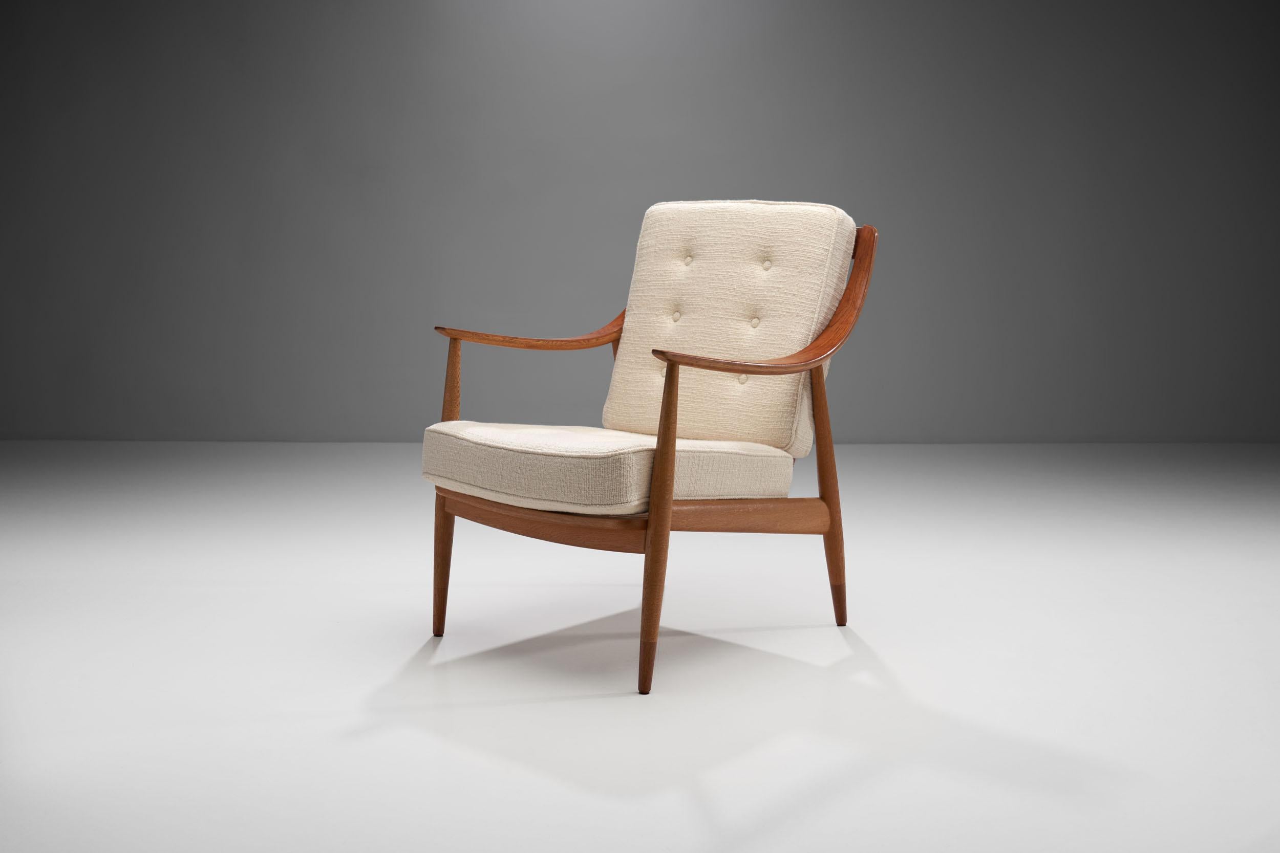 This is a beautiful Peter Hvidt & Orla Mølgaard-Nielsen designed model “FD 144” easy chair, made in Denmark in 1953. It was produced by France & Daverkosen Denmark.

This solid oak FD-144 Easy Chair by the designer duo, has distinctive, wide and