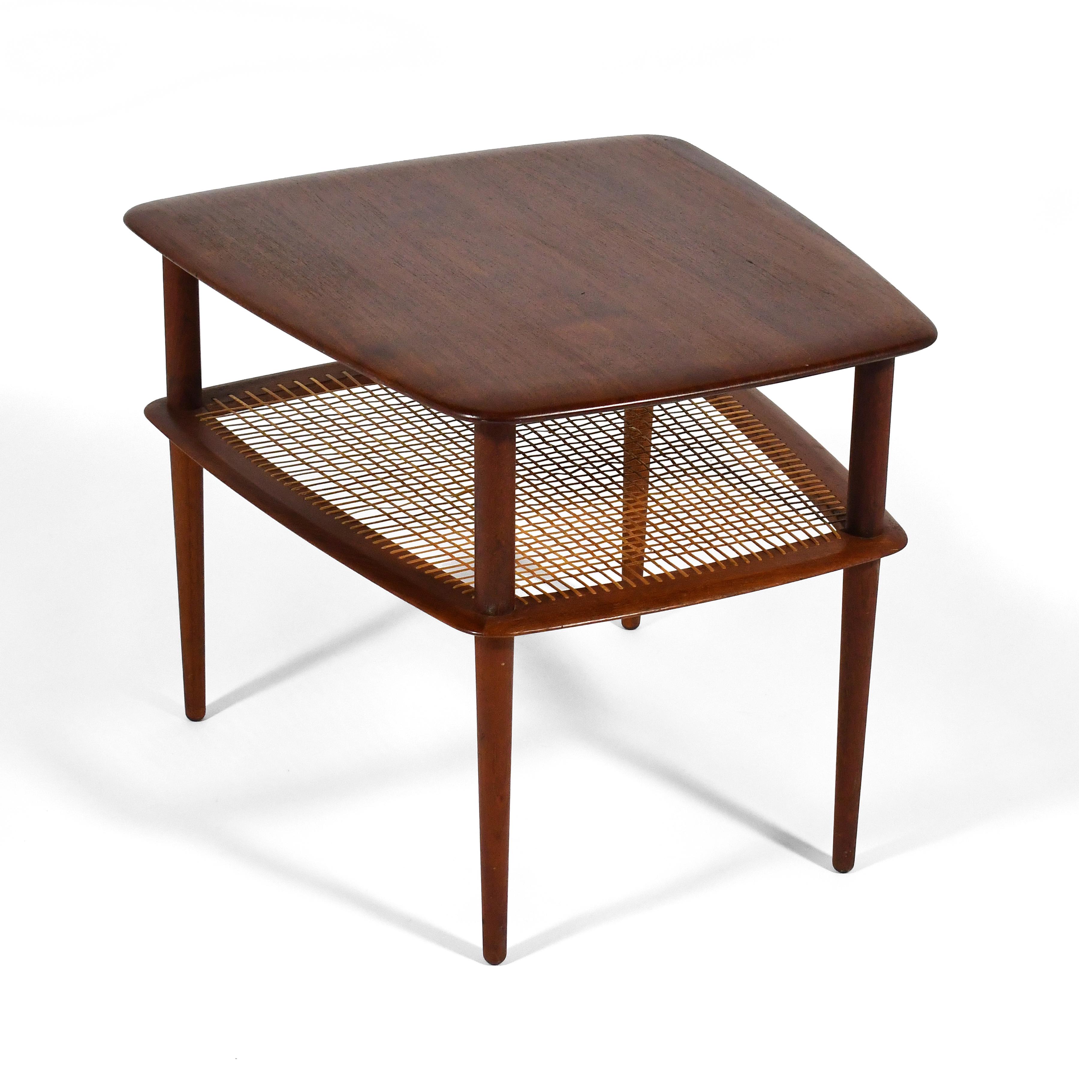 This Peter Hvidt & Orla Mølgaard-Nielsen model FD 521 side table from 1956 designed for France & Daverkosen features all solid teak construction and a cane lower shelf.
