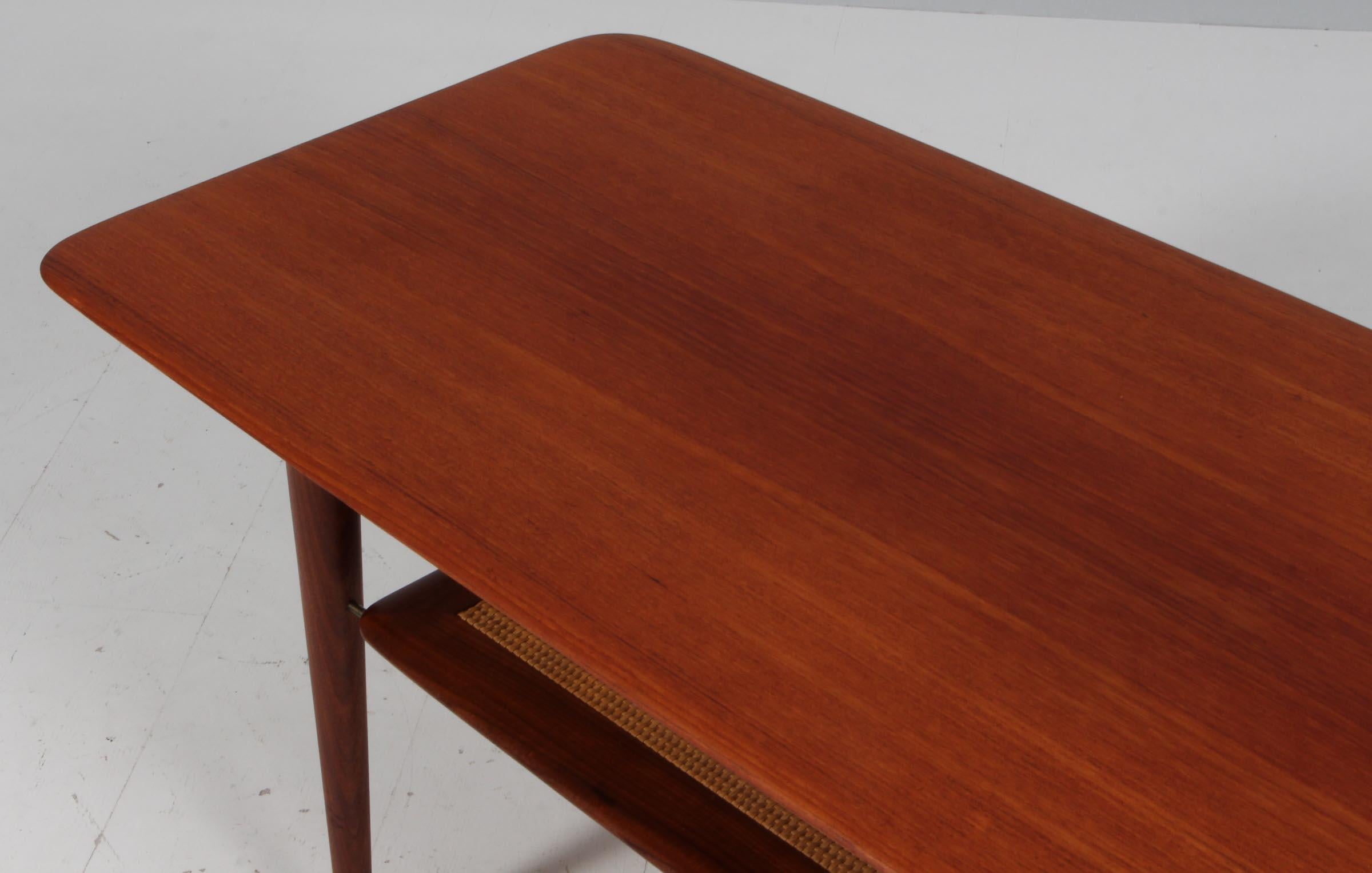 Peter Hvidt & Orla Mølgaard Nielsen sofa table in teak.

Cane shelf.

Made by France & Daverkosen in the 1960s.