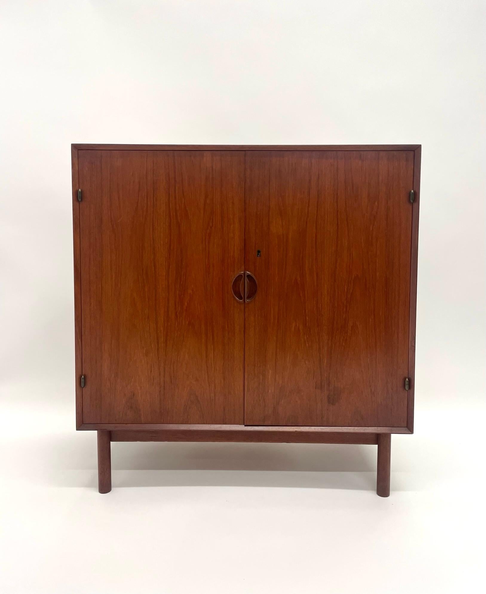 Peter Hvidt and Orla Molgaard-Nielsen solid teak cabinet. This two door cabinet opens to three sliding shelves, single lower shelf. Made of solid teak with dovetail joints on all sides. This cabinet shows off danish craftsmanship at its best.