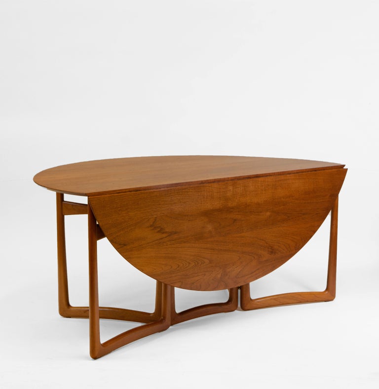 Stunning large teak drop leaf oval dining table, designed by Peter Hvidt & Orla Mølgaard. Made in Denmark for France & Søn. Maker's label. Circa 1950-60s.

The table shows sculptural designed legs, which open to an oval shape on piano and brass ball