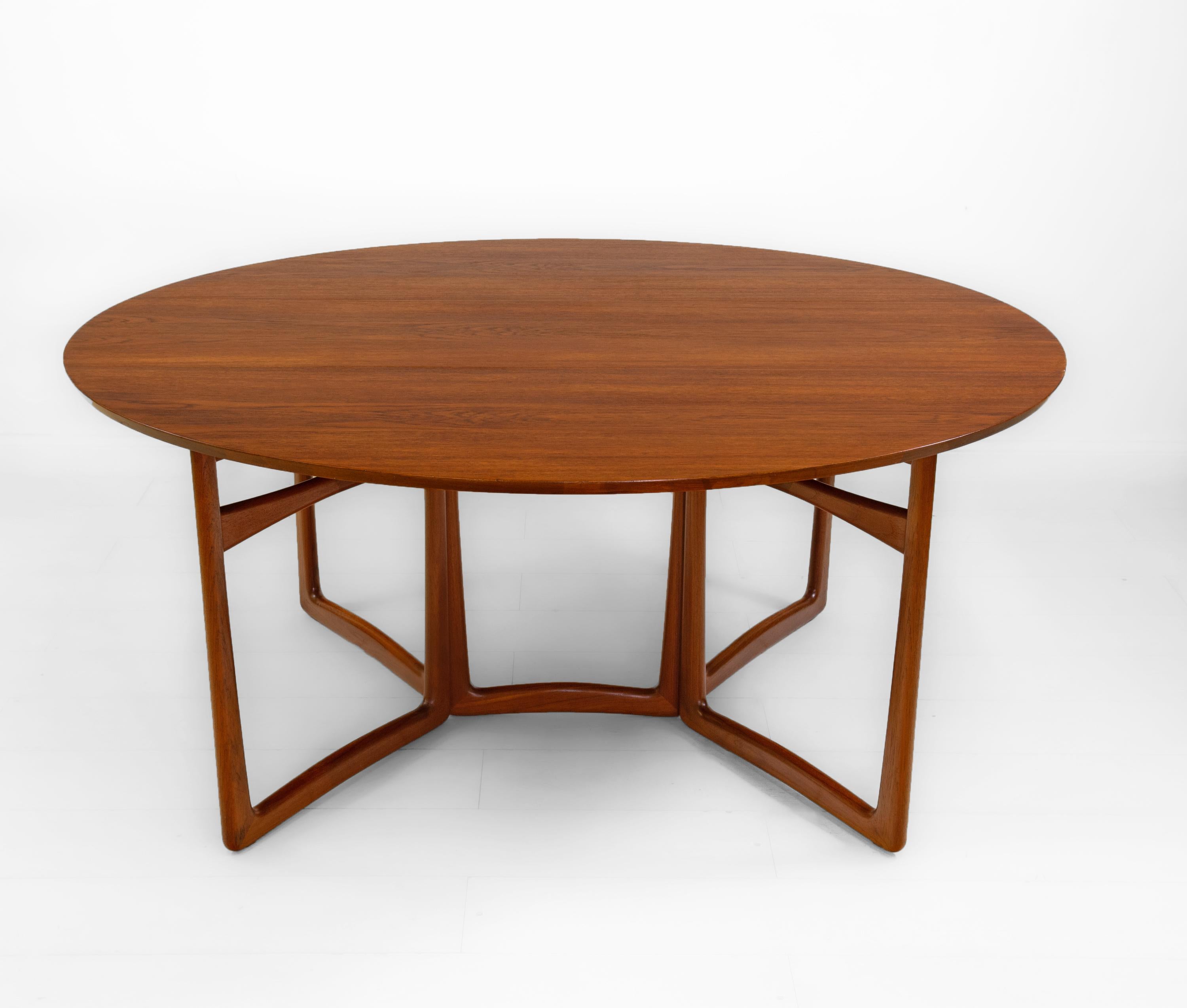 Stunning large teak drop leaf oval dining table, designed by Peter Hvidt & Orla Mølgaard. Made in Denmark for France & Søn. Maker's label. Circa 1950-60s.

The table shows sculptural legs which open to an oval shape on piano and brass ball hinges.