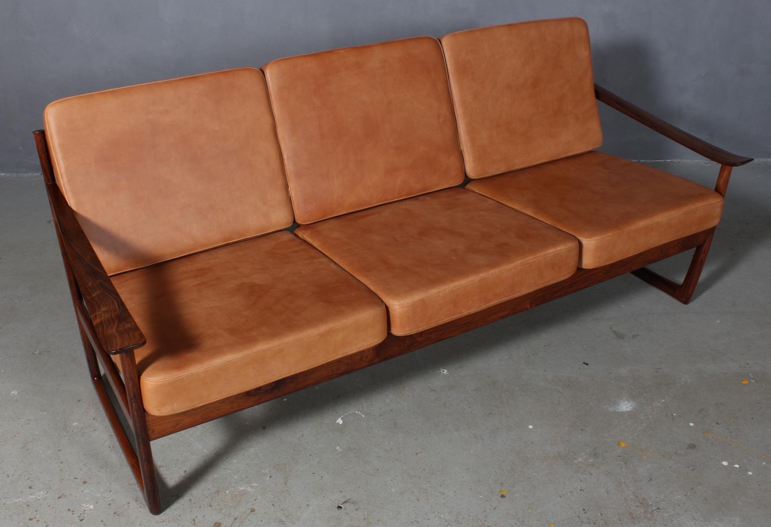 Peter Hvidt & Orla Mølgaard Nielsen three-seat sofa in rosewood. New upholstered cushions with vintage tan aniline leather.

Made by France & Daverkosen, Model 130.
