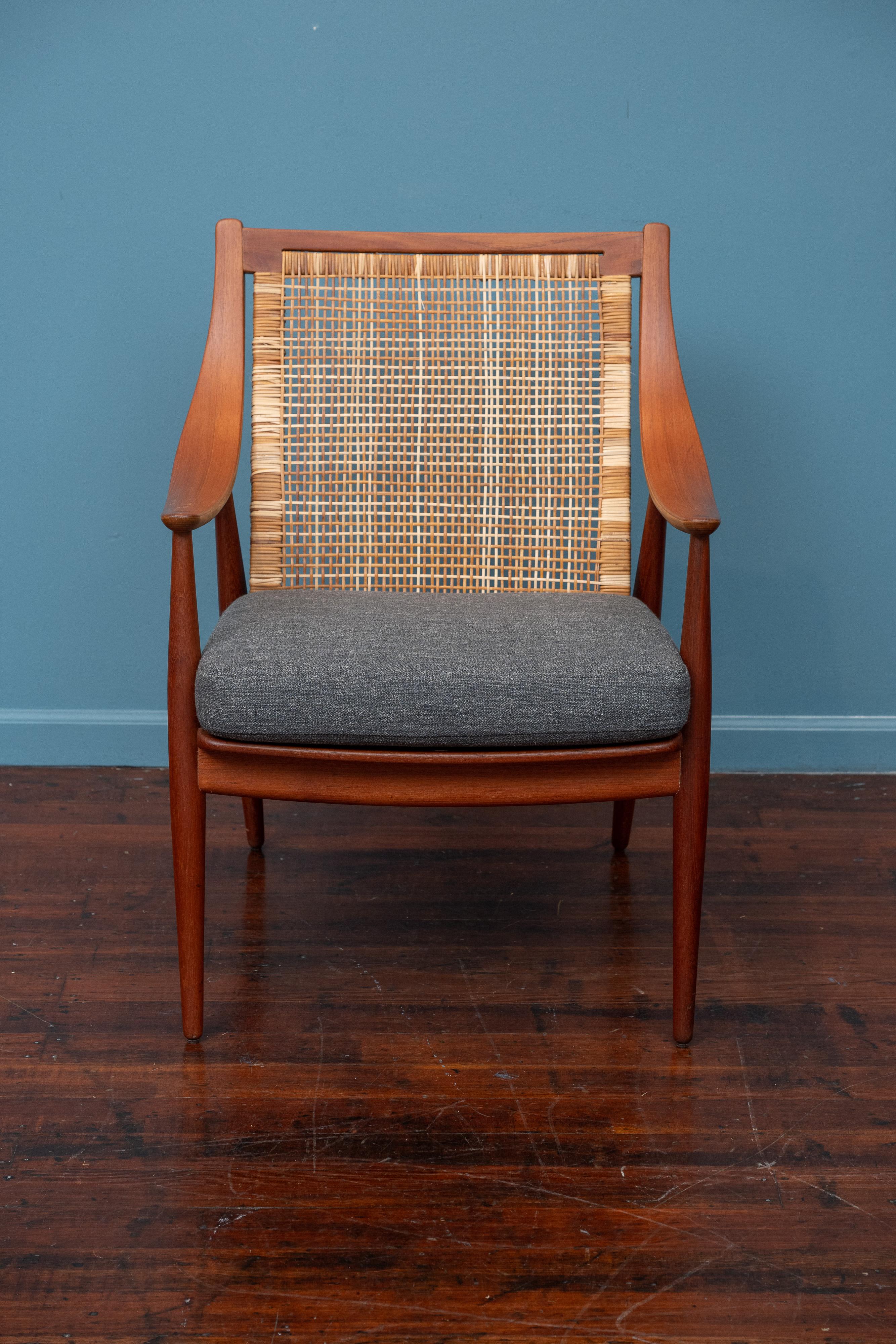 Peter Hvidt & Orla Molgaard design armchair model FD 146, Denmark. Elegant and comfortable lounge chair made with a teak frame, cane back with a new upholstered cushion. Newly refinished and restored cane, labeled.