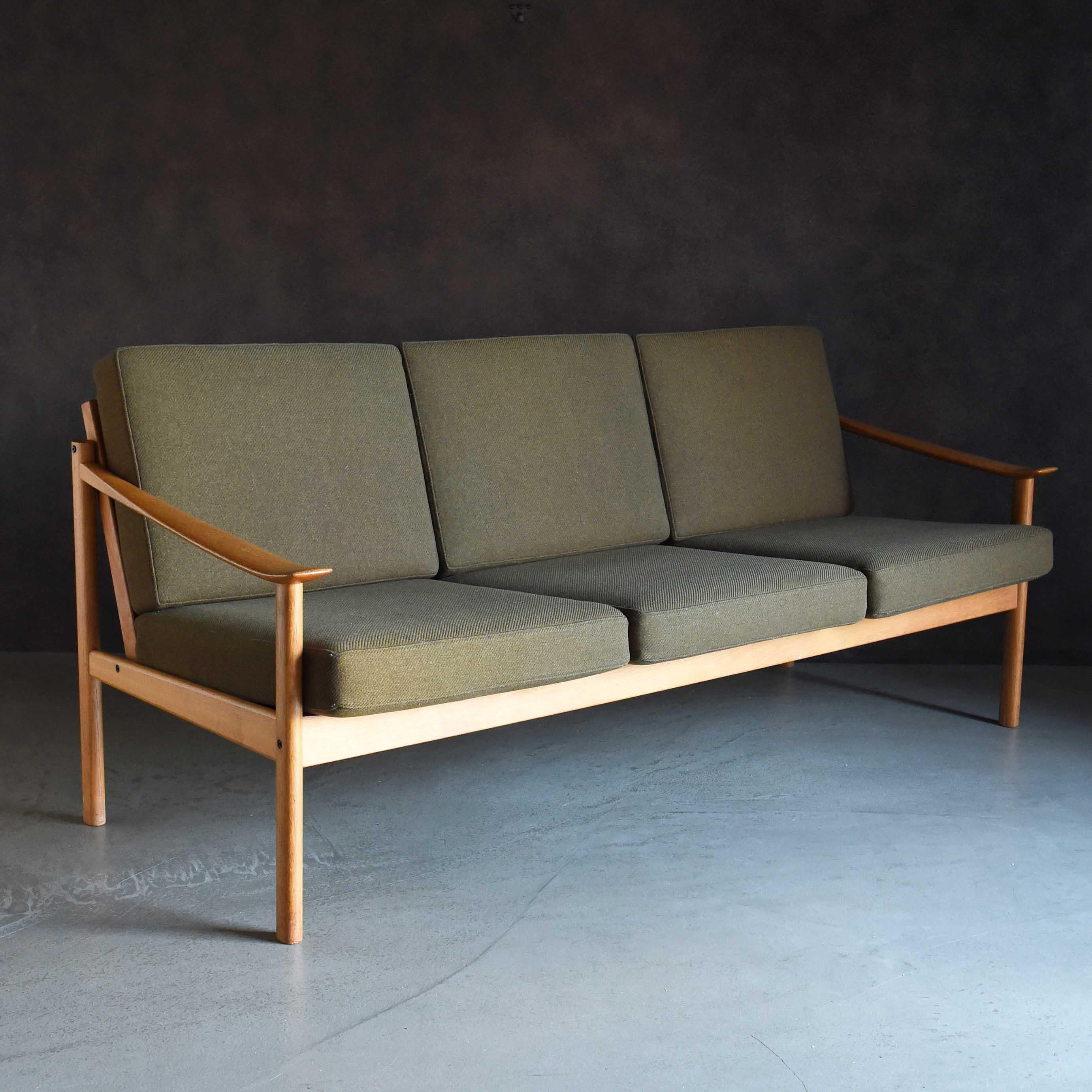Dieses 3-Sitzer-Sofa wurde von den dänischen Designern Peter Hvidt und Orla Molgaard Nielsen entworfen und zeichnet sich durch seine schön geschwungenen Armlehnen aus. Das Gesamtdesign ist sauber und der Sitz ist geräumig und bequem. Der Hersteller