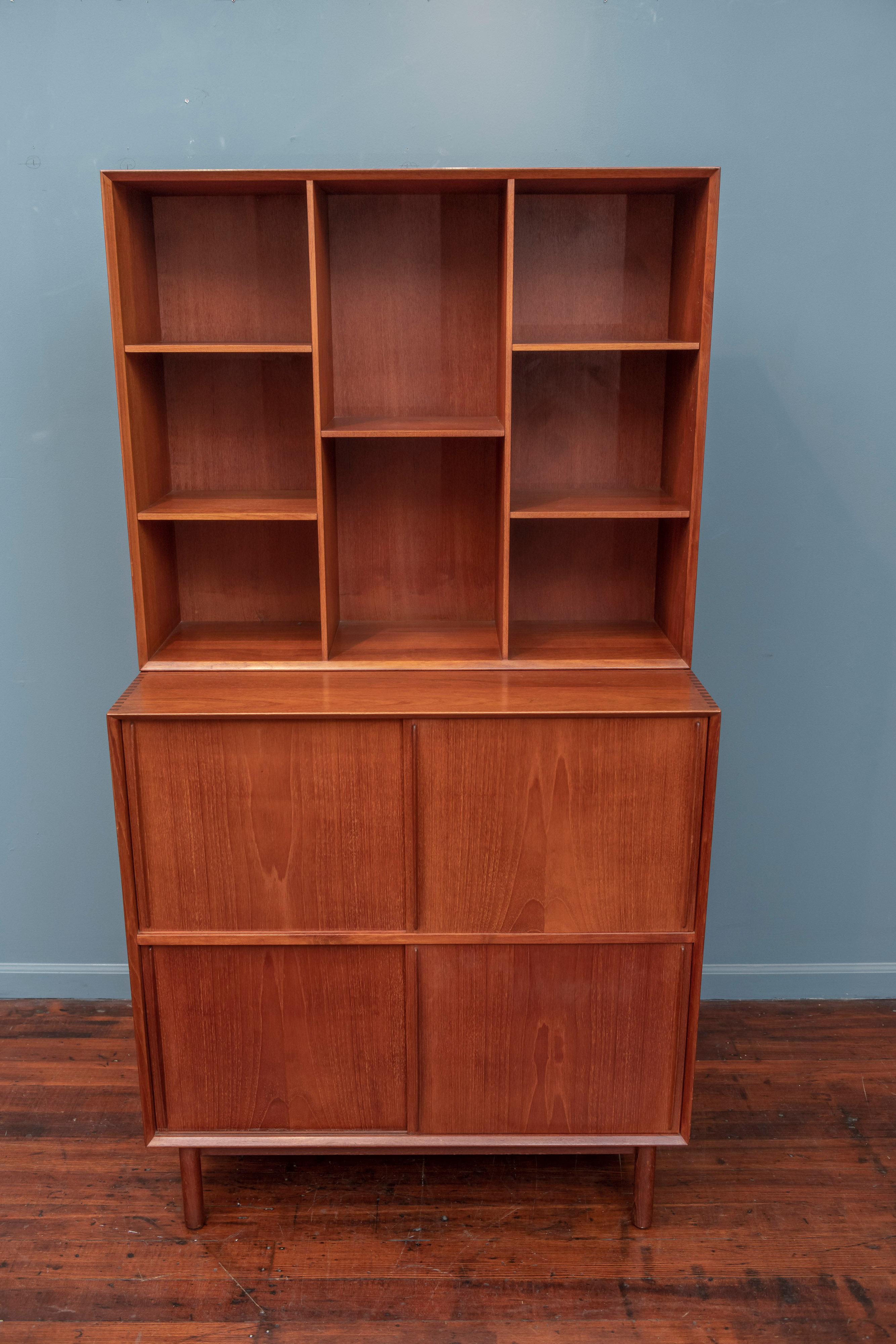 Peter Hvidt & Orla Molgaard Nielsen design bookcase cabinet, Denmark. High quality construction in solid teak with dovetail joinery and adjustable shelves throughout. Unusual lower sliding doors that glide smoothly without effort concealing two