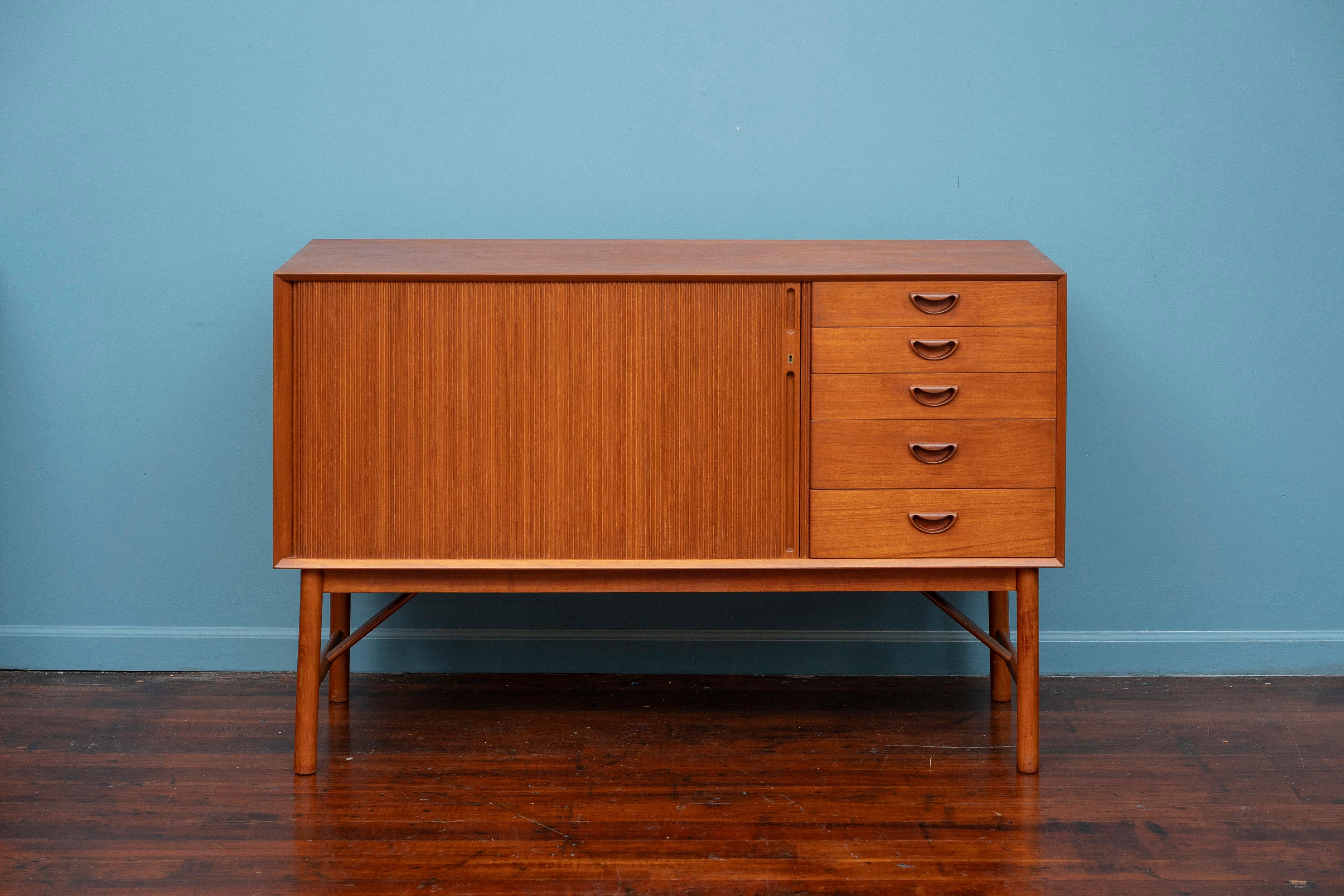 Peter Hvidt & Orla Molgaard-Nielsen credenza, Model 309. High quality construction and materials crafted in solid teak with a tambour door. Sophisticated cabinetry skills make this credenza or cabinet an eye catching timeless design for any