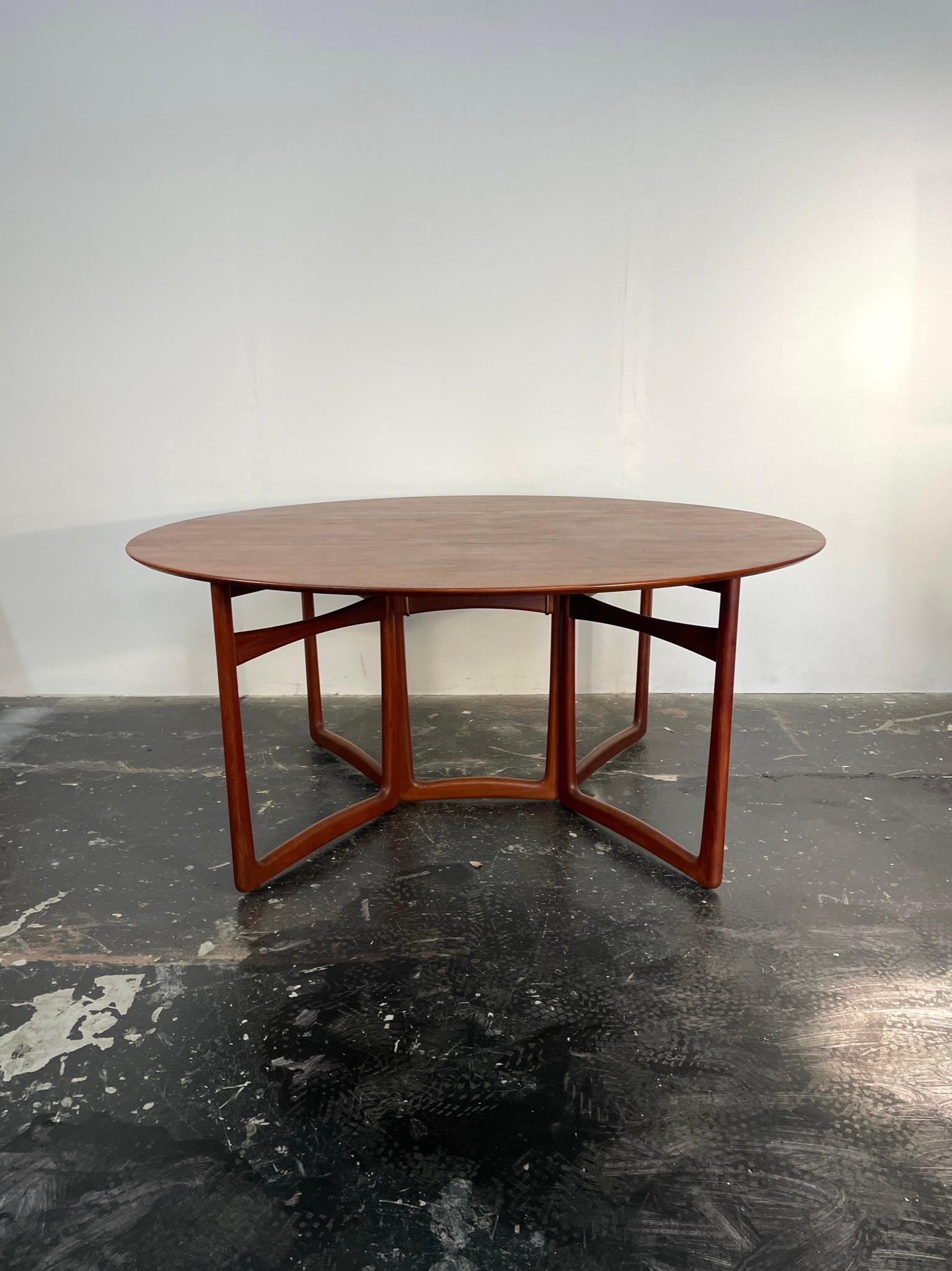 A solid teak, drop leaf dining table by Peter Hvidt and Orla Molgaard-Nielsen for France & Son Denmark. Beautiful high quality construction with amazing brass details.

This is going to be a stunning conversation. Elegant oval shape with old-growth