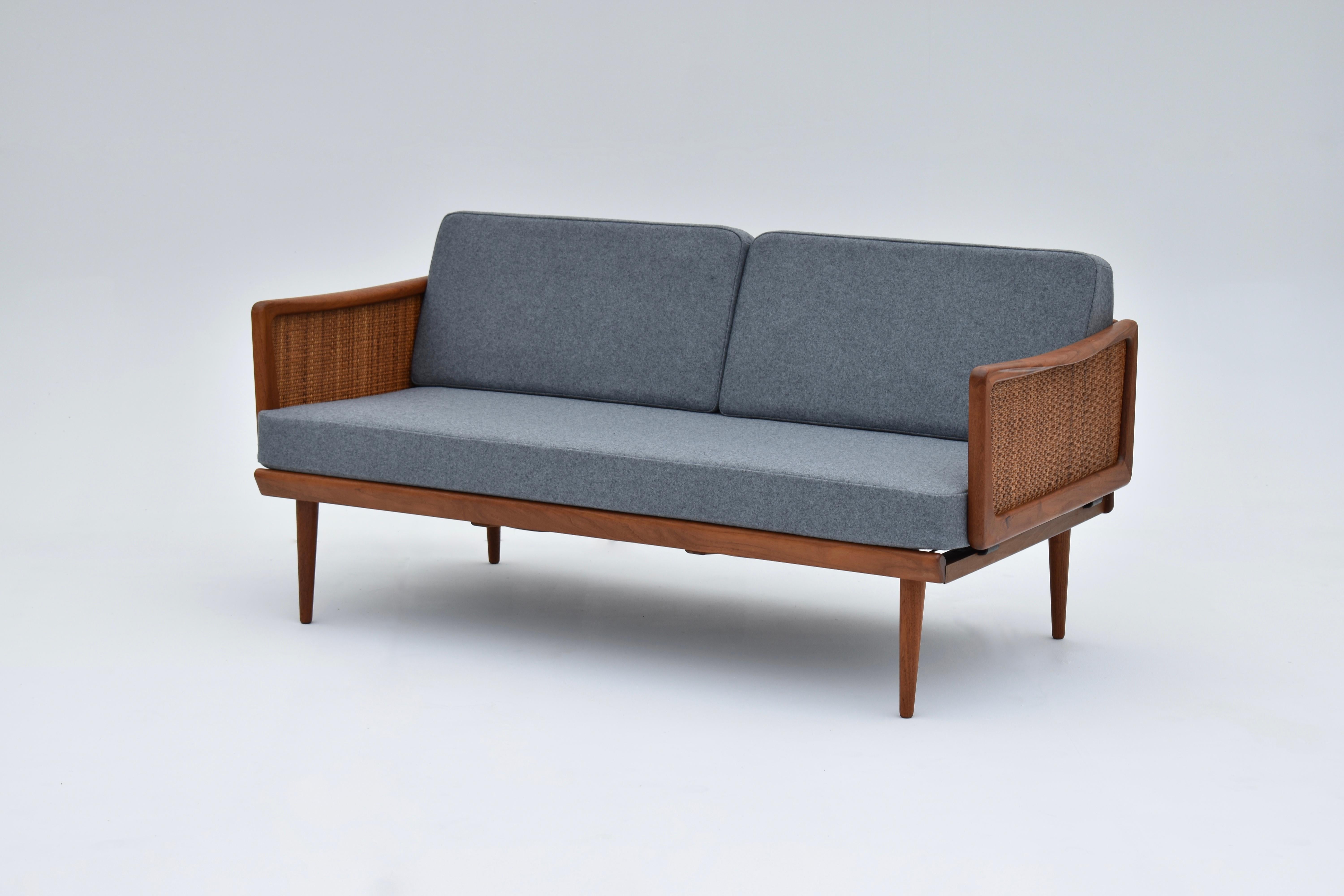 A superb model 453 daybed designed by Peter Hvidt & Orla Mølgaard Nielsen for France & Søn.

An incredibly versatile piece of furniture, the two sculptural rattan detailed armrest fold down at the press of a button, they can then be used as casual