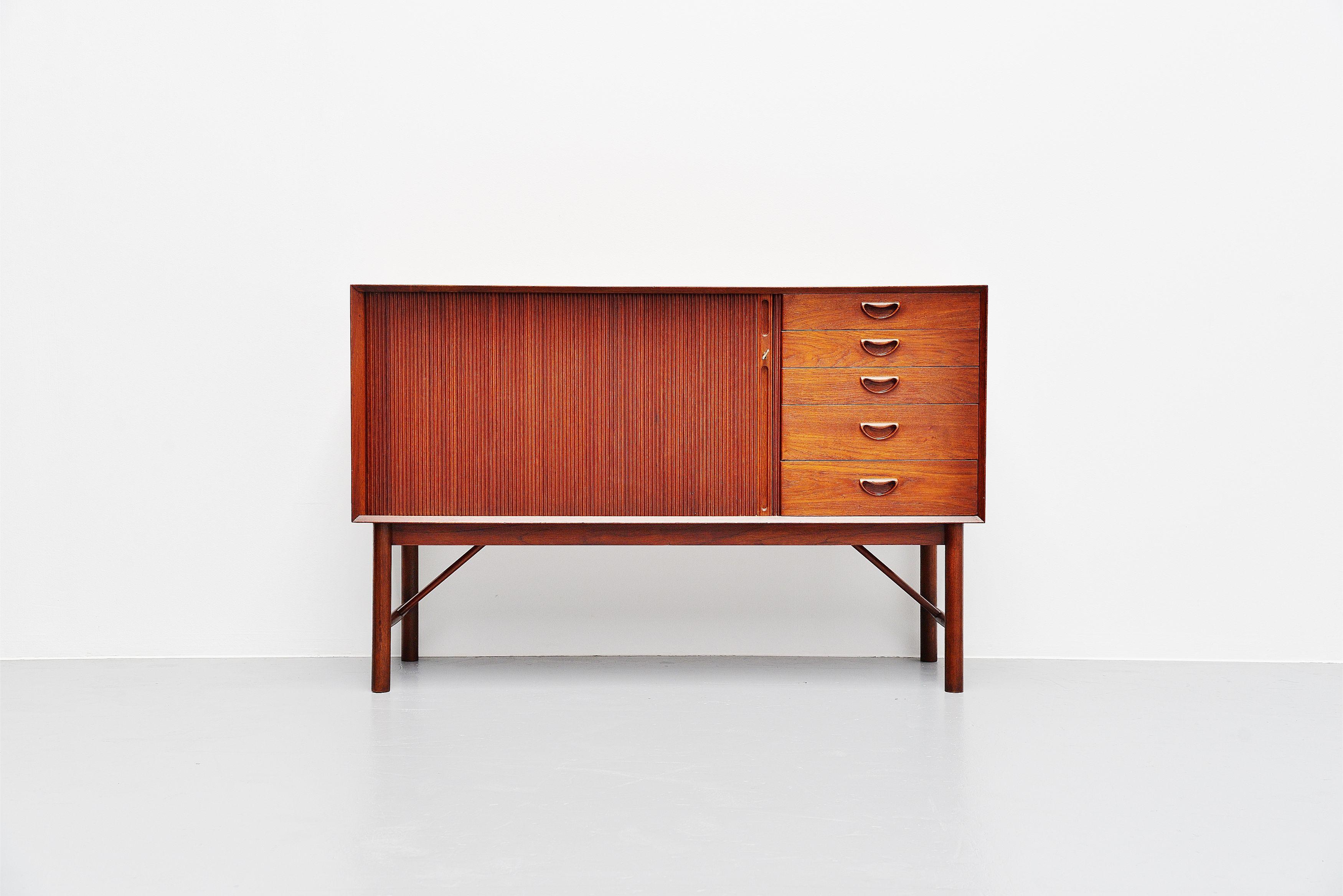 Super finished small sideboard designed by Peter Hvidt and Orla Molgaard Nielsen and manufactured by Soborg Mobler, Denmark, 1958. The cabinet has a long tambour door on the left and 5 drawers on the right. The cabinet is made of solid teak wood and