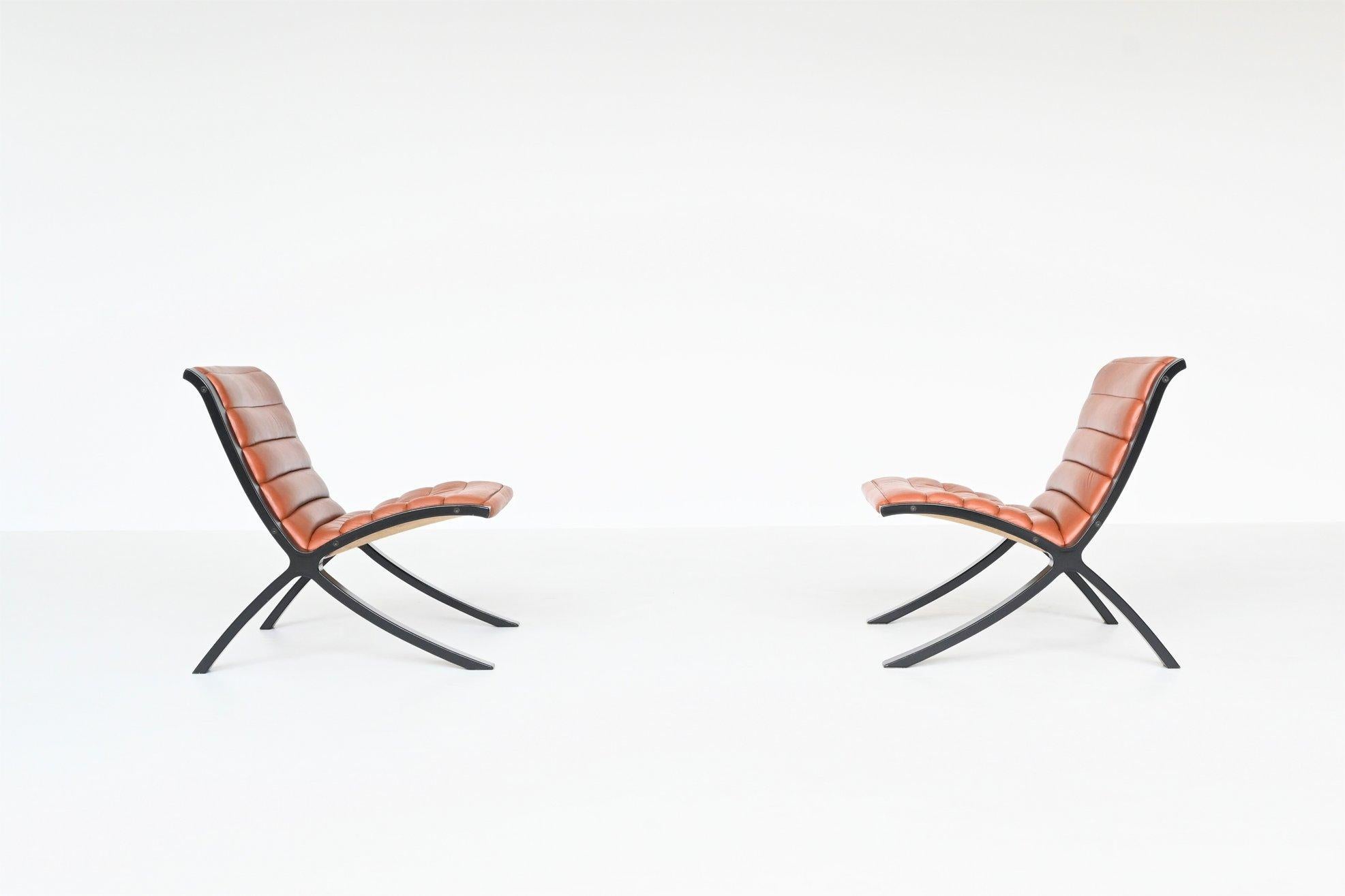 Fantastically shaped pair of lounge chairs model X-Chair designed by Peter Hvidt & Orla Molgaard-Nielsen for Fritz Hansen, Denmark 1979. These sculptural chairs feature a black lacquered beech plywood frame with padded brown leather upholstery. The