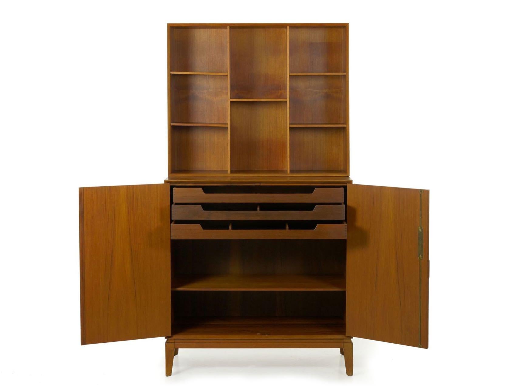 With the exposed finger-joinery and the distinctive sculpted teak pulls signature to Peter Hvidt and Orla Mølgaard Nielsen’s designs, this two-part bookcase-over-cabinet is a powerful strikepoint piece that perfectly balances form and function. It
