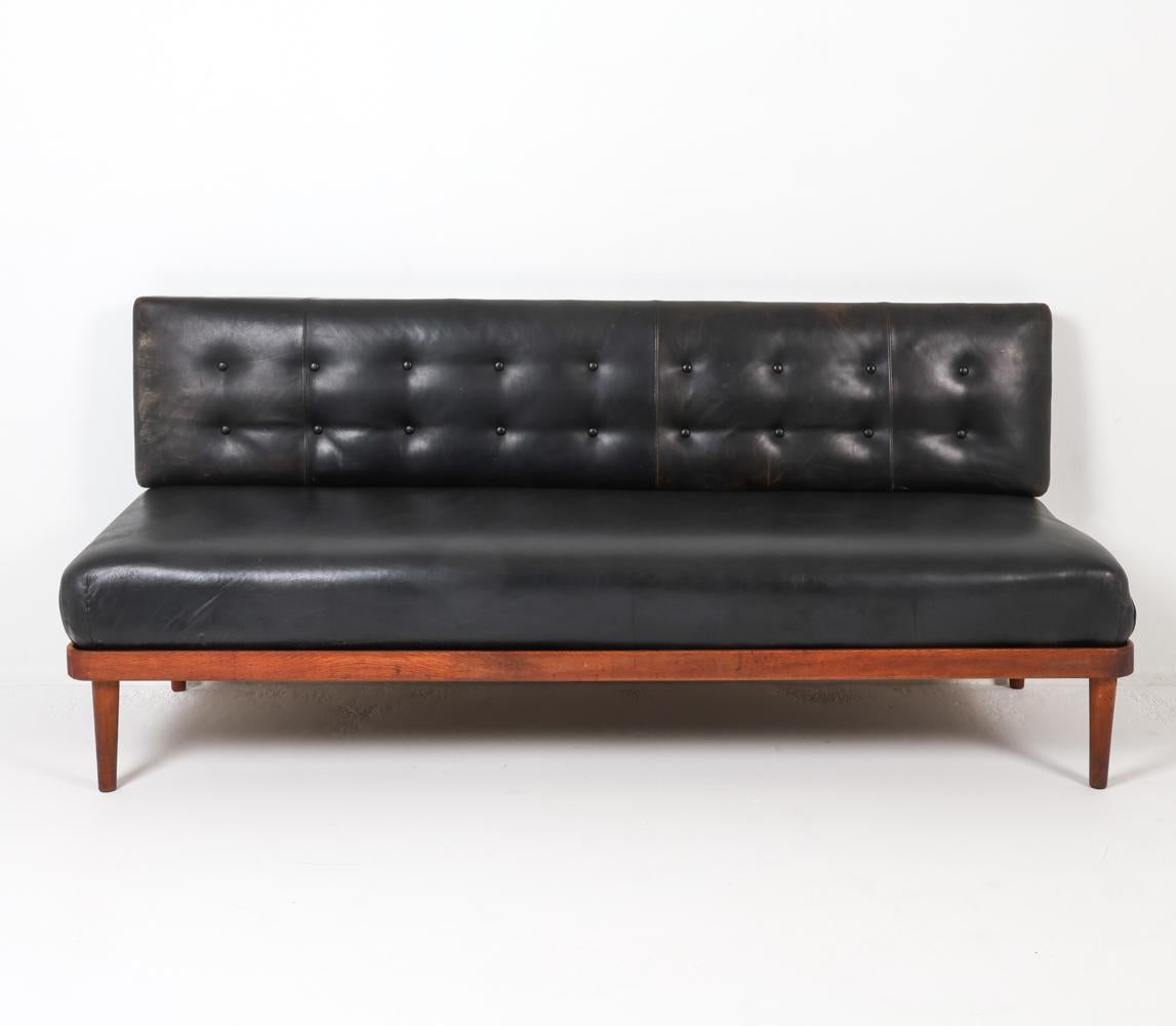 Ce magnifique lit de jour danois en teck et cuir incarne l'élégance raffinée de l'esthétique du design de Peter Hvidt dans les années 1950. Cette pièce, qui témoigne de l'artisanat et de l'ingéniosité scandinaves, répond à la fois au besoin d'un