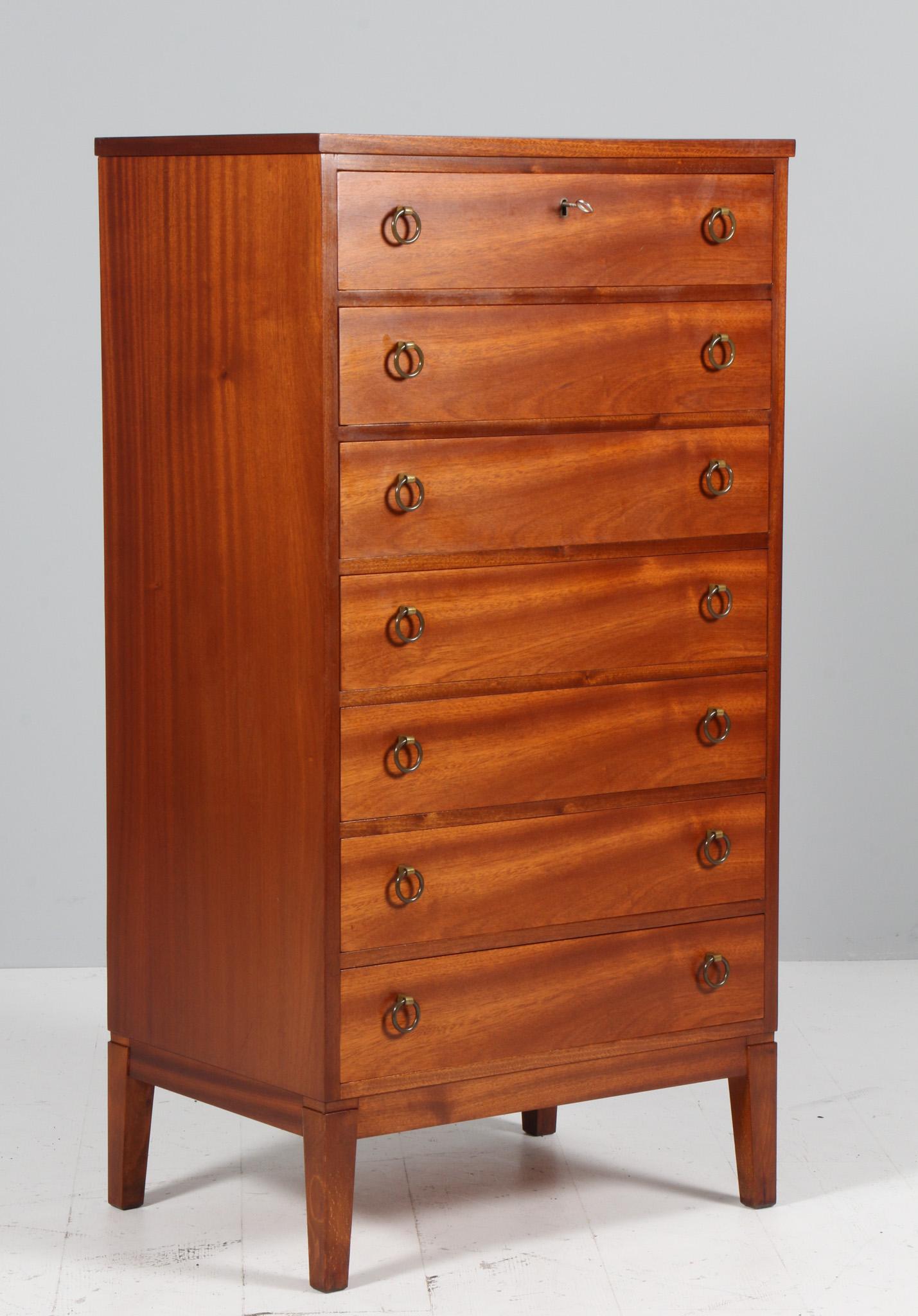 Peter Hvidt early tallboy chest of drawers made in mahogany. With drawers, handles made of patinated brass.

Made by Søborg møbler.