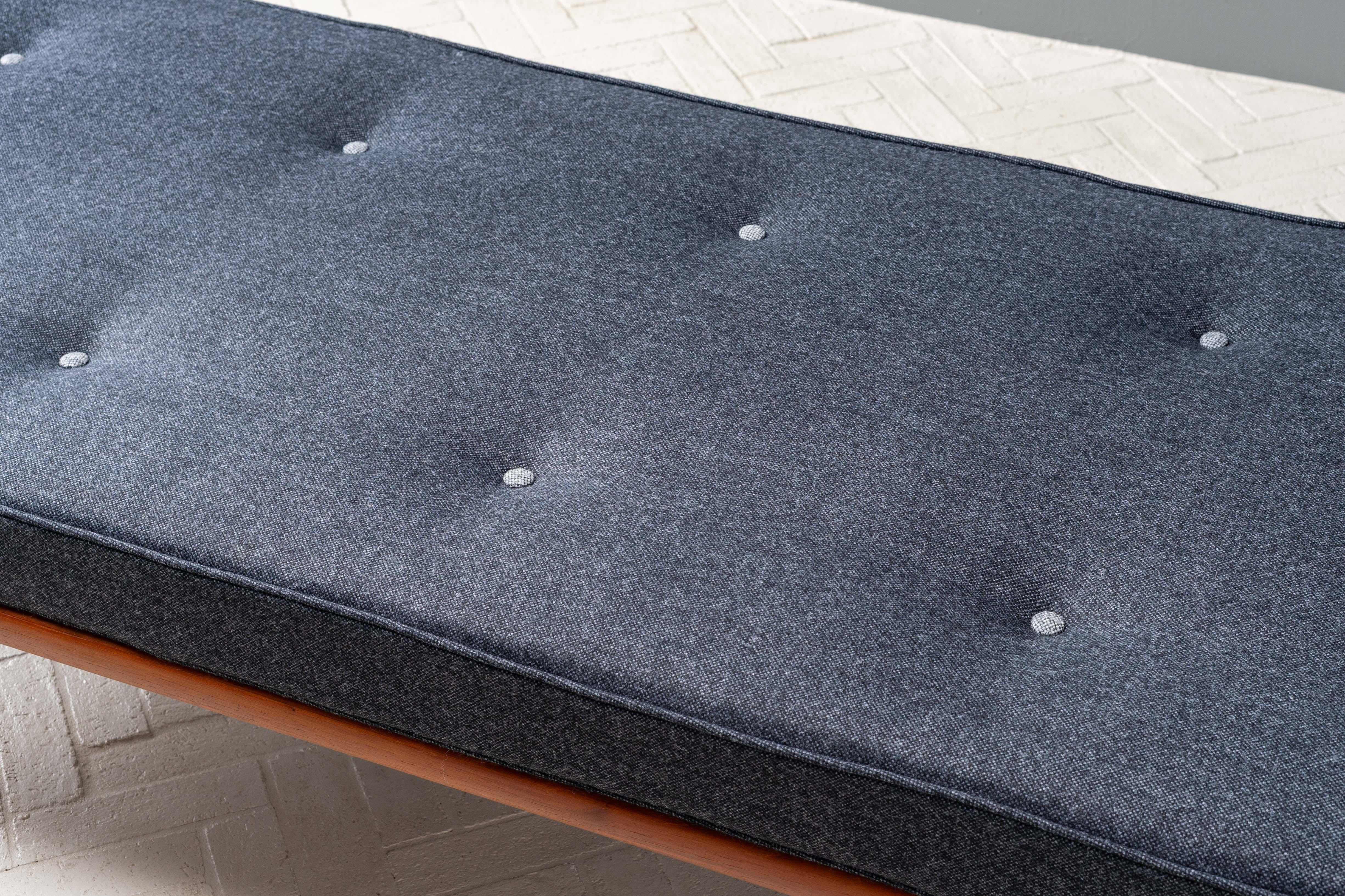 Dinamarca, hacia la década de 1950. Un Daybed Minerva de Peter Hvidt & Orla Mølgaard-Nielsen para France & Son. Presenta una base minimalista de teca maciza con perfil bullnose apoyada en patas cónicas torneadas. El cojín del banco reversible ha