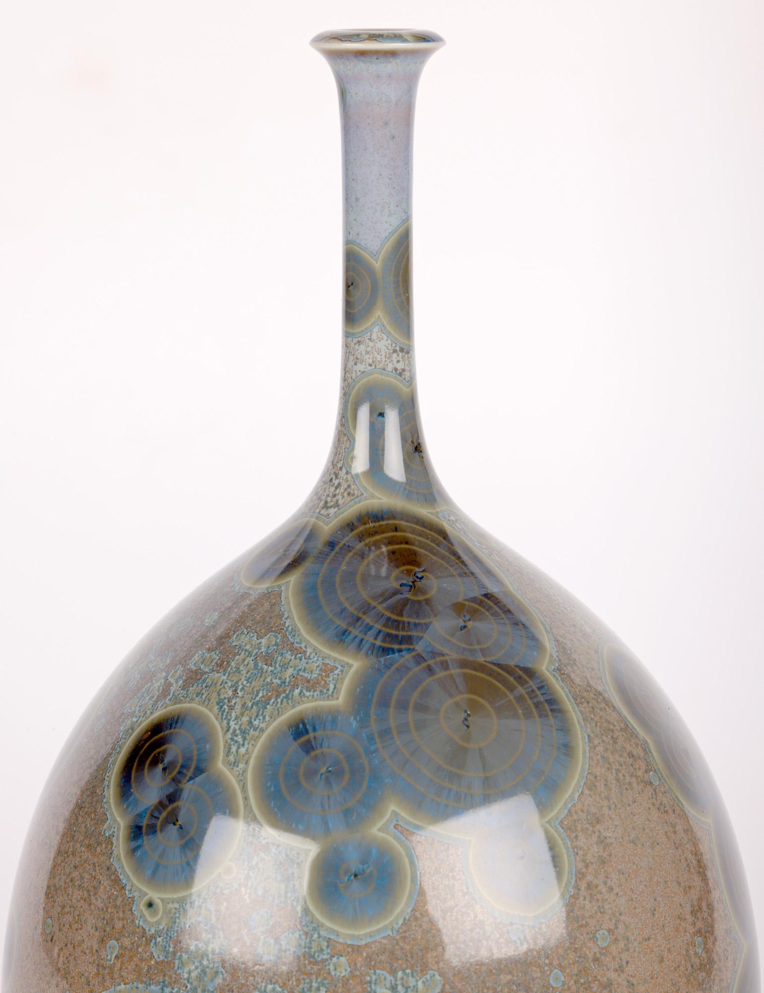 A stunning and exceptional studio pottery crystalline glazed porcelain bottle vase signed AH to the base and dated 1986. The vase is finely potted standing on a narrow unglazed round base with a round bulbous shaped body and with a tall slender neck